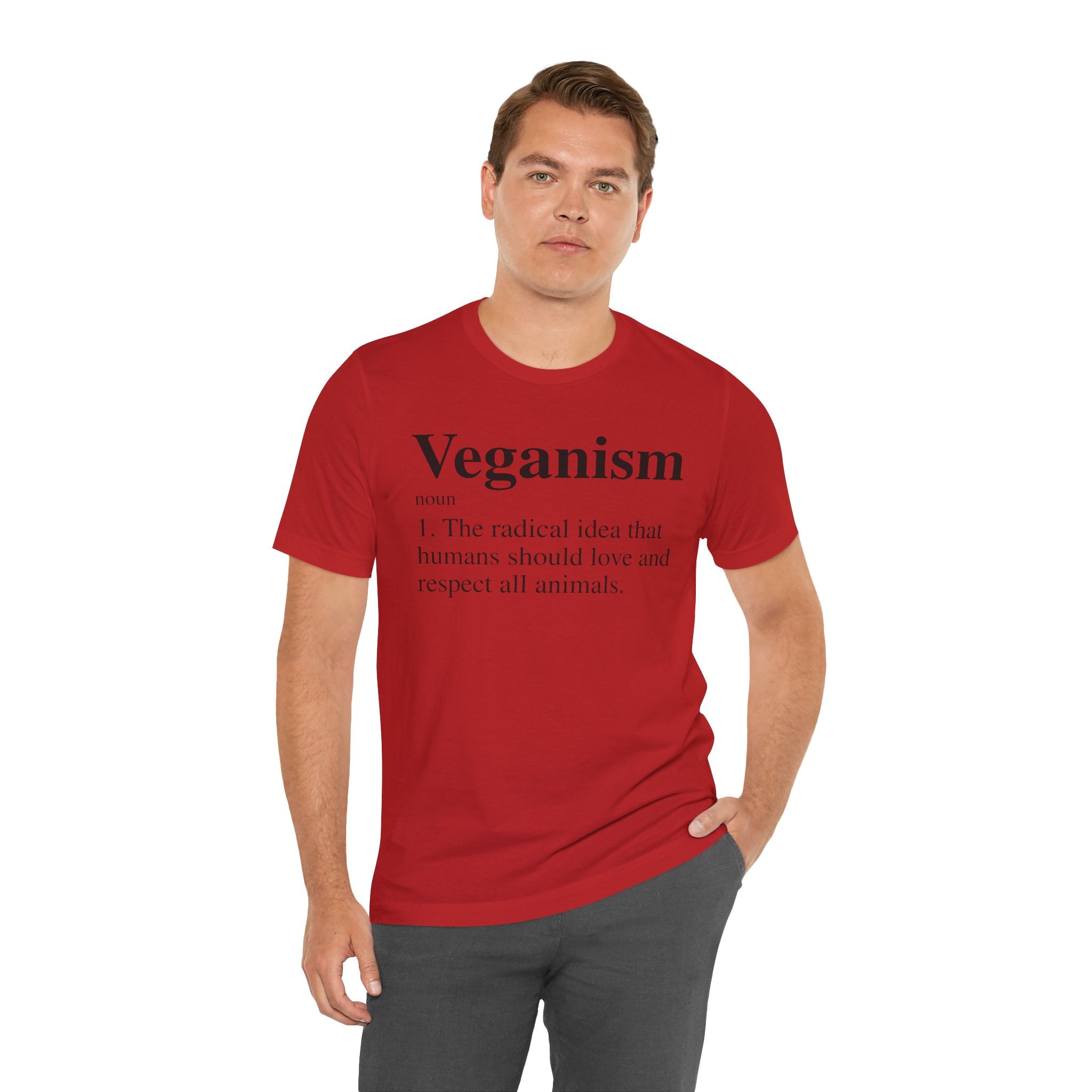 Man in a red Veganism T-Shirt with the word "veganism" and its definition printed on the front, standing against a white background.