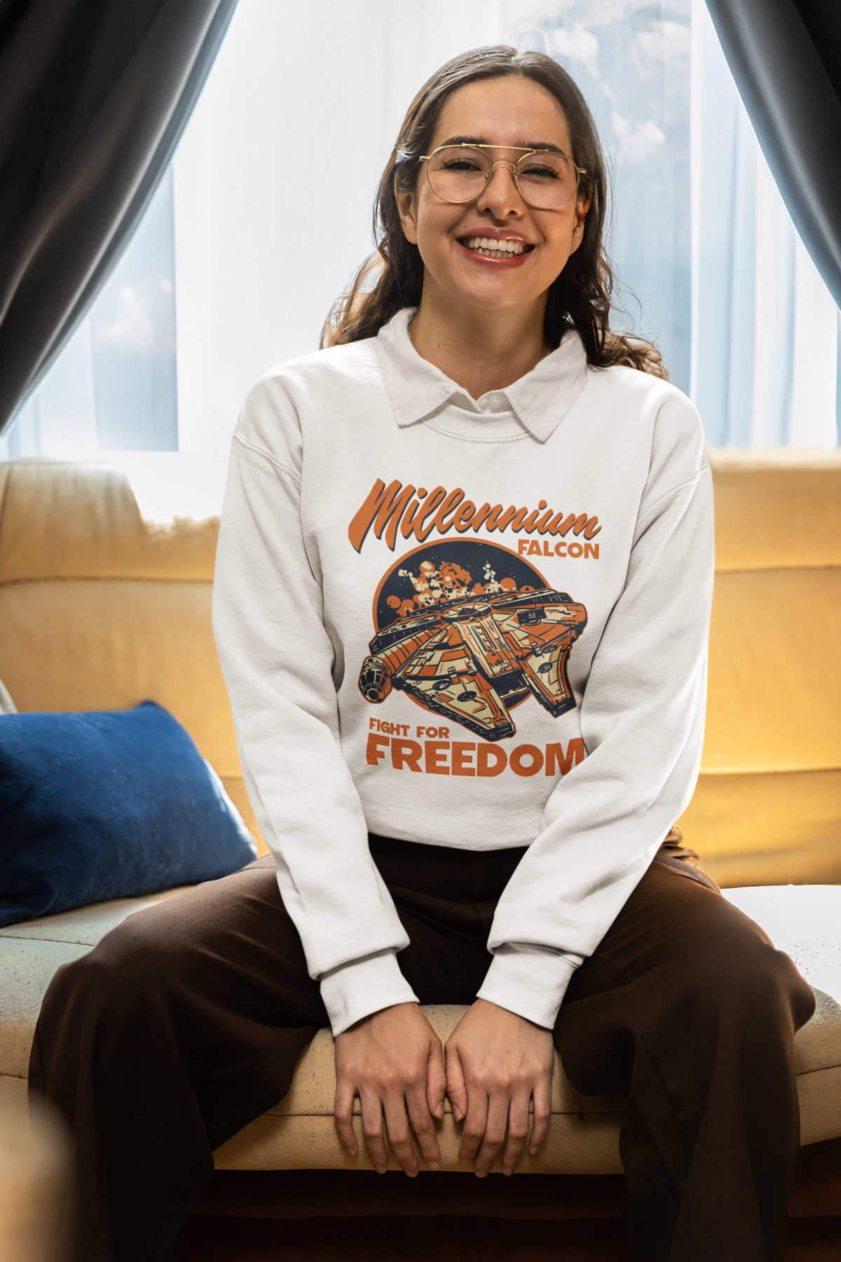 'Millennium Falcon Fight for Freedom' sweatshirt in white, woman sitting wearing it indoors, cozy sci-fi fan gift