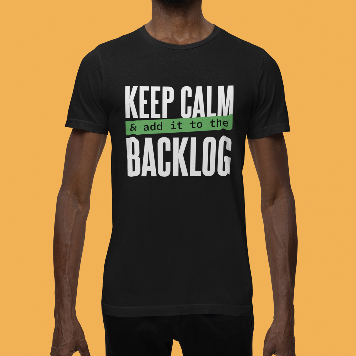 'Keep Calm and Add It to the Backlog' t-shirt in black, man model wearing it against an orange background, agile team gift