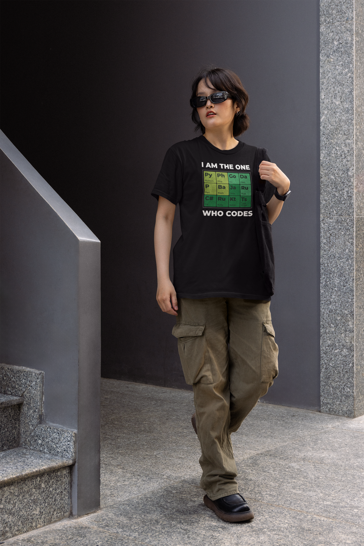 'I Am the One Who Codes' periodic table t-shirt in black, man walking outdoors, funny programmer tee