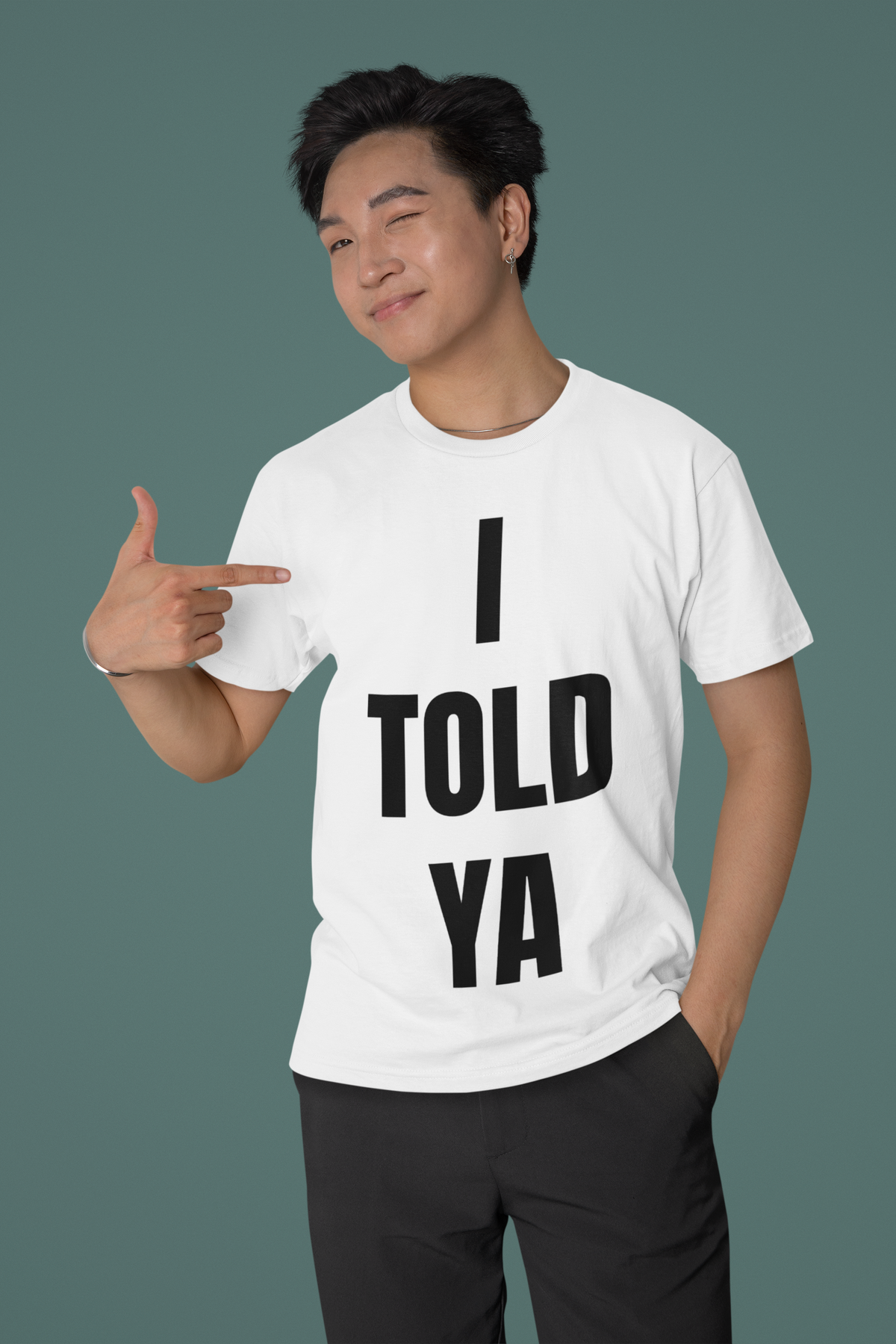 I Told Ya white t-shirt worn by a man pointing at the print, funny sarcastic shirt for friends
