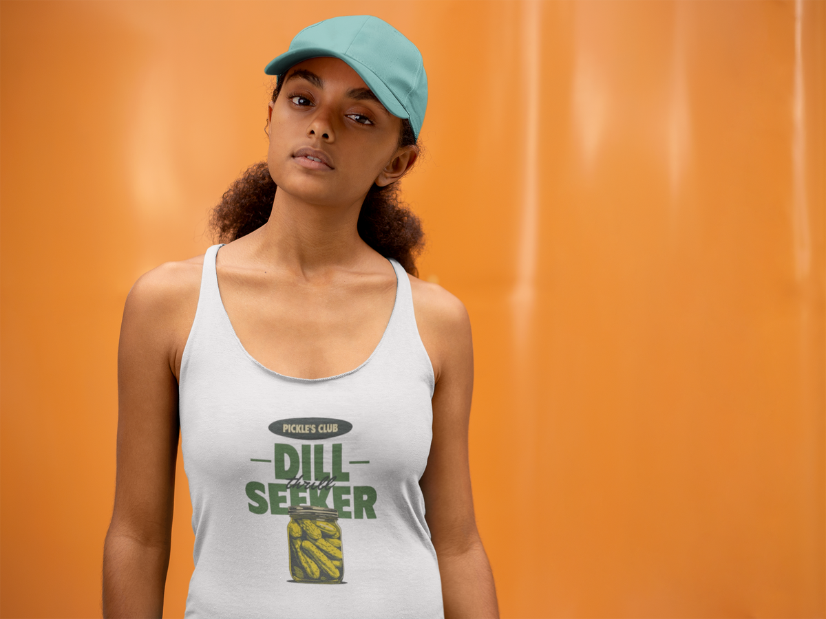 'Dill Seeker' racerback tank top in white, woman wearing it by an orange wall, Tank Top mockup, Geekpsters