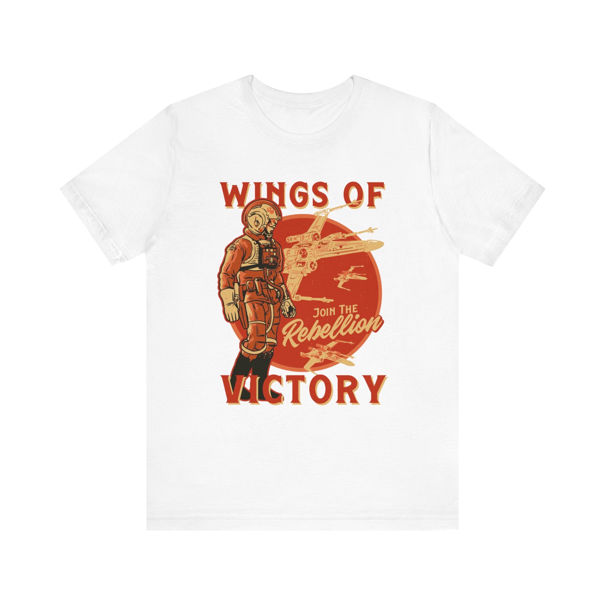 The "Wings of Victory T-Shirt" is a classic unisex jersey tee in white, featuring a striking graphic of a pilot and fighter jets against a setting sun. The text "Wings of Victory" and "Join the Rebellion" are highlighted in red and orange tones. Made from soft cotton, this T-shirt ensures comfort while showcasing a vibrant print that stands out.