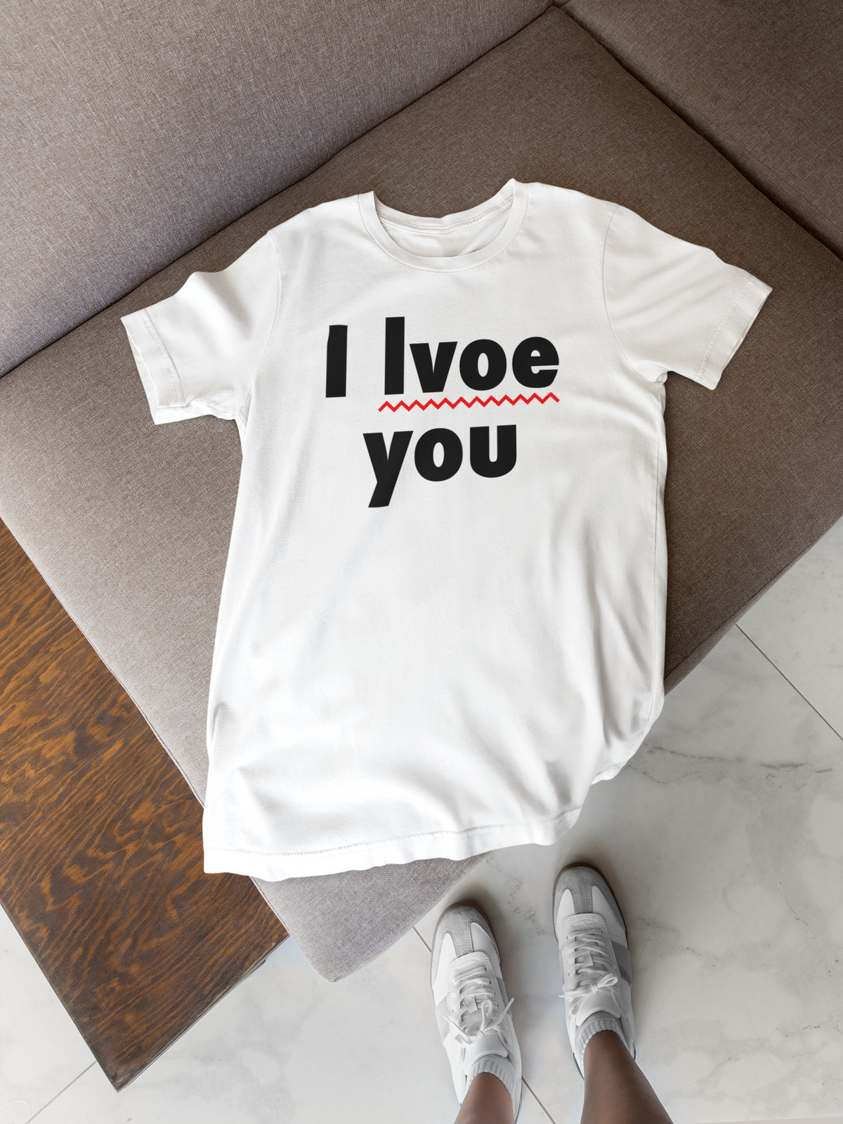 'I Lvoe You' typo t-shirt in white, flat lay on a wooden floor, funny sarcastic gift for couples