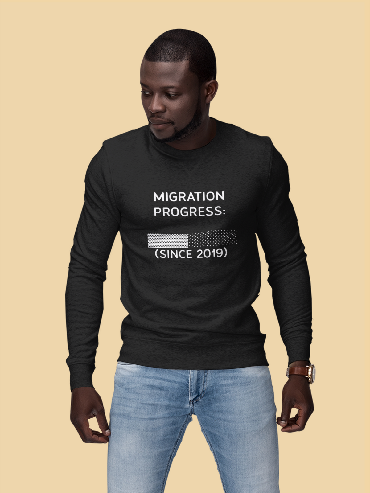 'Migration Progress: (Since 2019)' sweatshirt in black, man wearing it against a tan backdrop, funny it gift