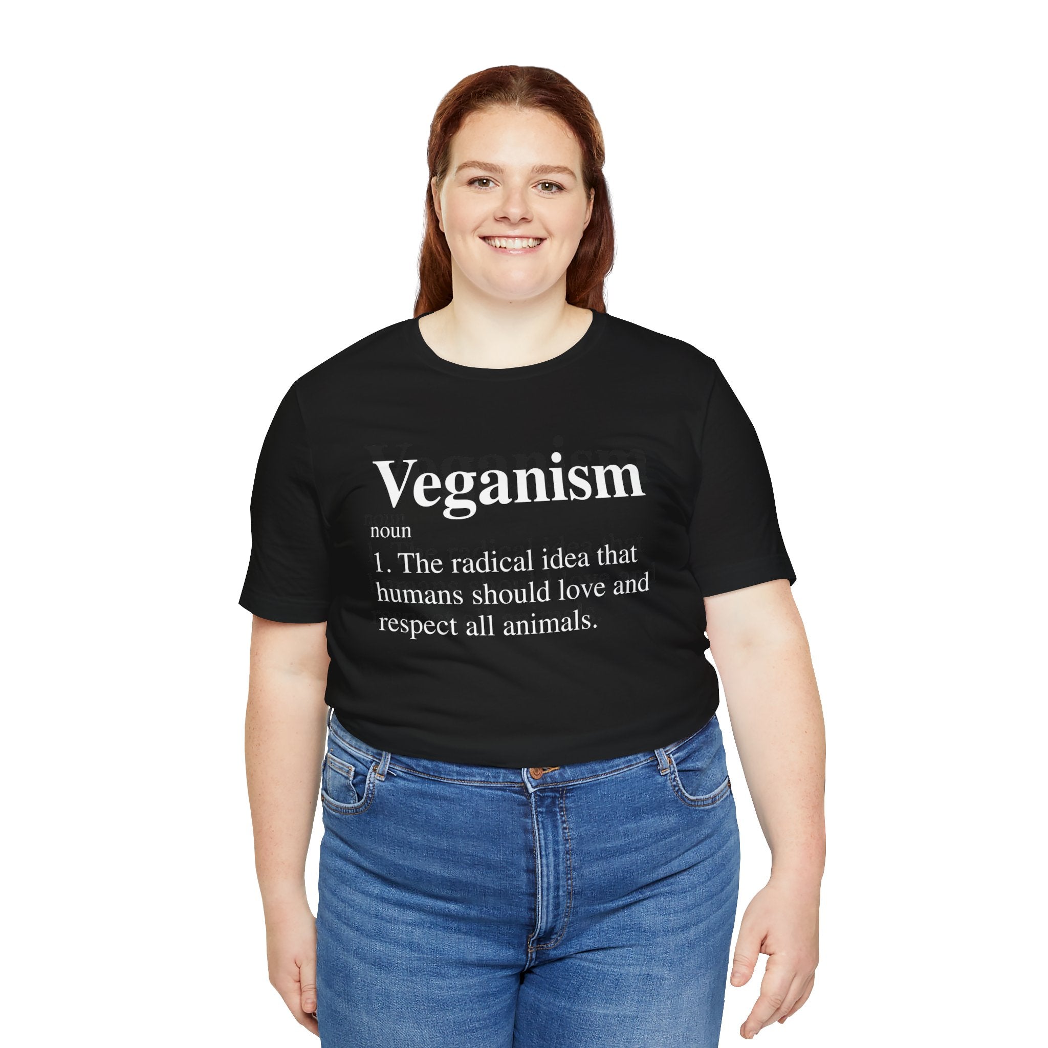 A woman with long hair wearing a black Veganism T-Shirt, paired with blue jeans, smiling at the camera.