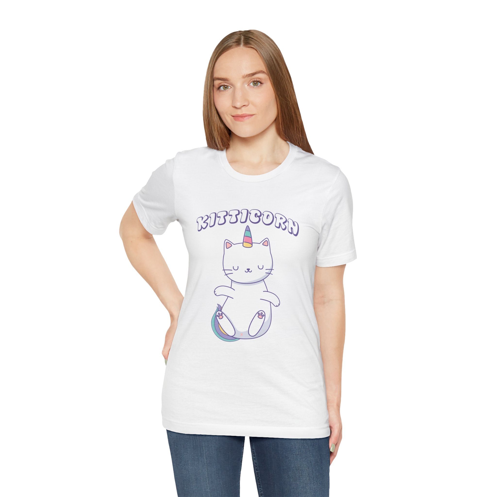 Woman in a white Kitticorn jersey tee with a cartoon cat design, standing against a plain background.