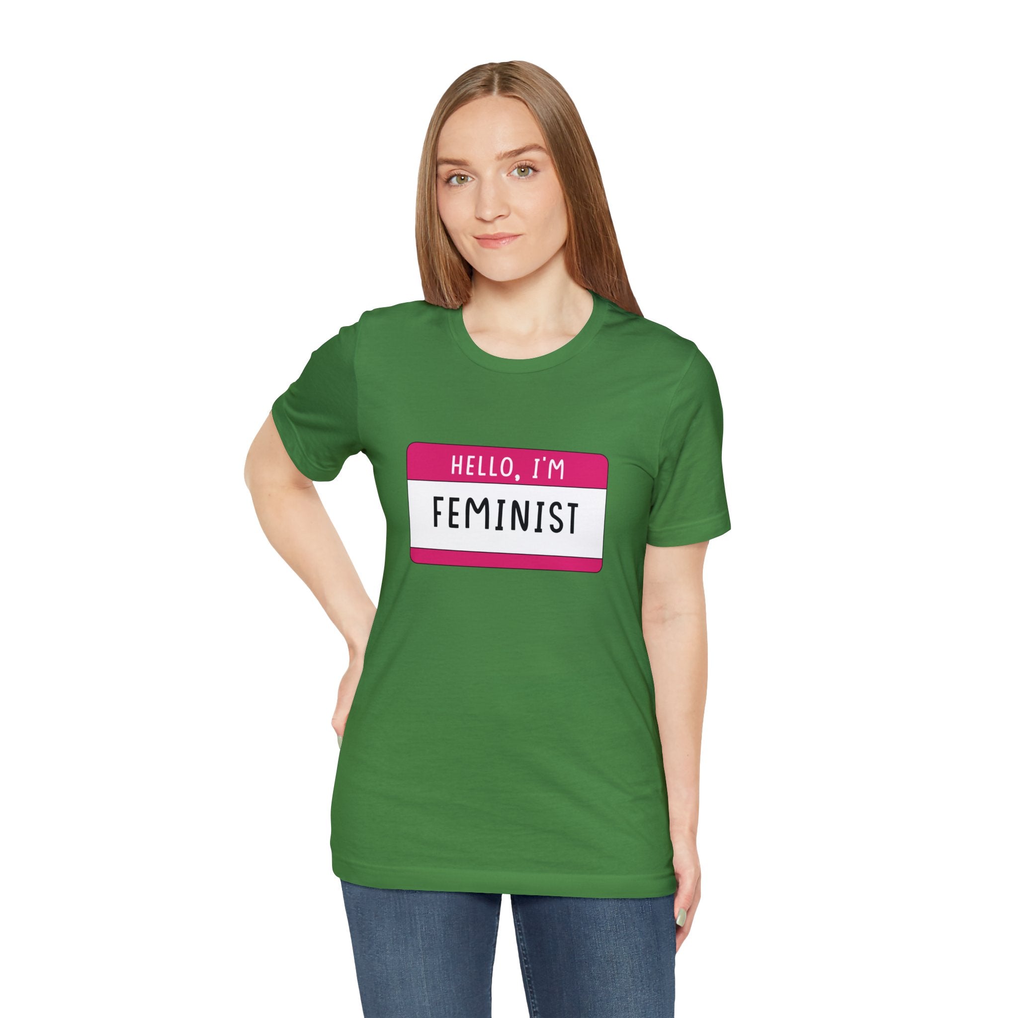 Woman in a green Hello, I'm Feminist T-shirt with an "hello, I'm feminist" badge printed on the front.