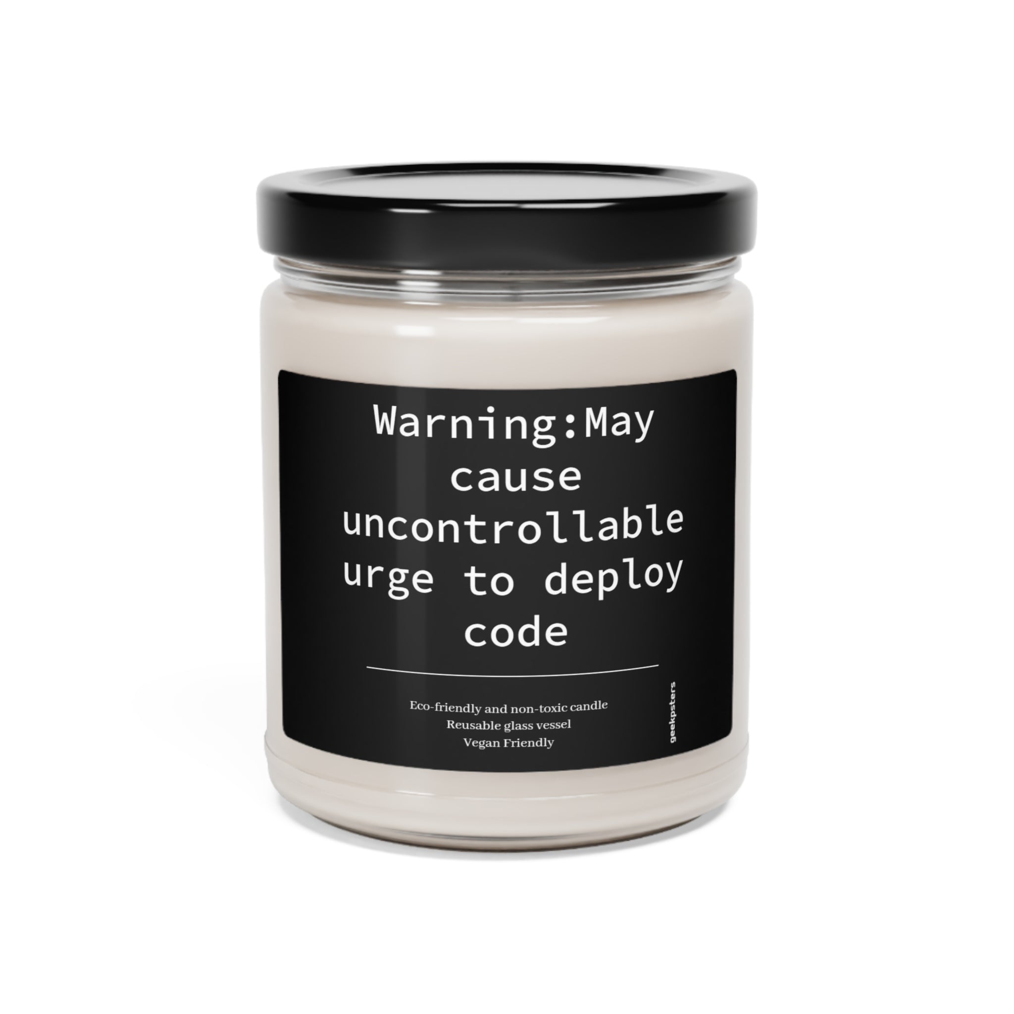 A jar of Caution May Cause Urge to Deploy - Scented Soy Candle with a humorous label that reads, "warning: may cause uncontrollable urge to deploy code," highlighting its eco-friendliness and vegan properties.