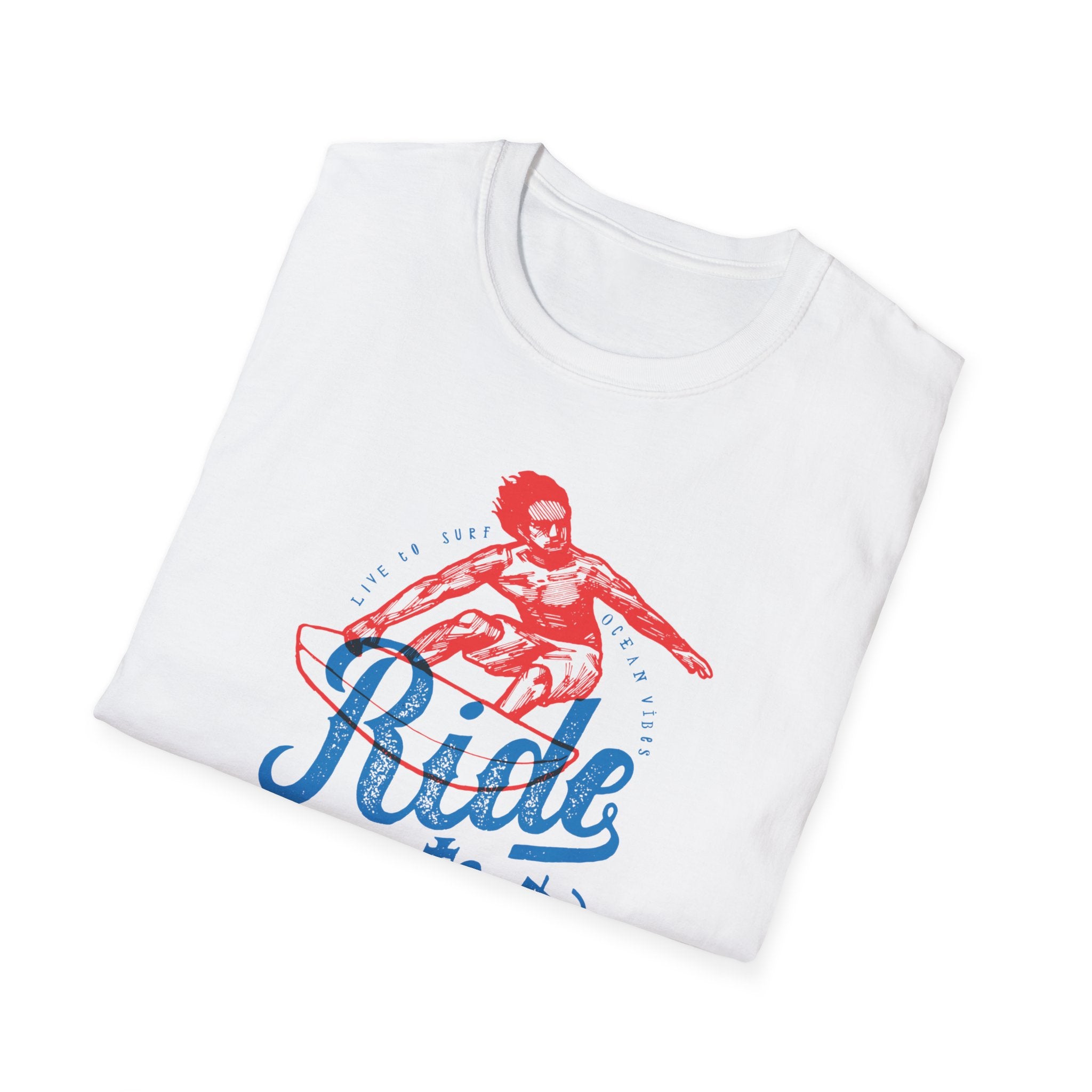 A neatly folded white T-shirt showcasing a fashionable design with a red and blue illustration of a surfer, adorned with the text "Ride Into the Sun T-Shirt" and "Live to Surf, Ocean Vibes.