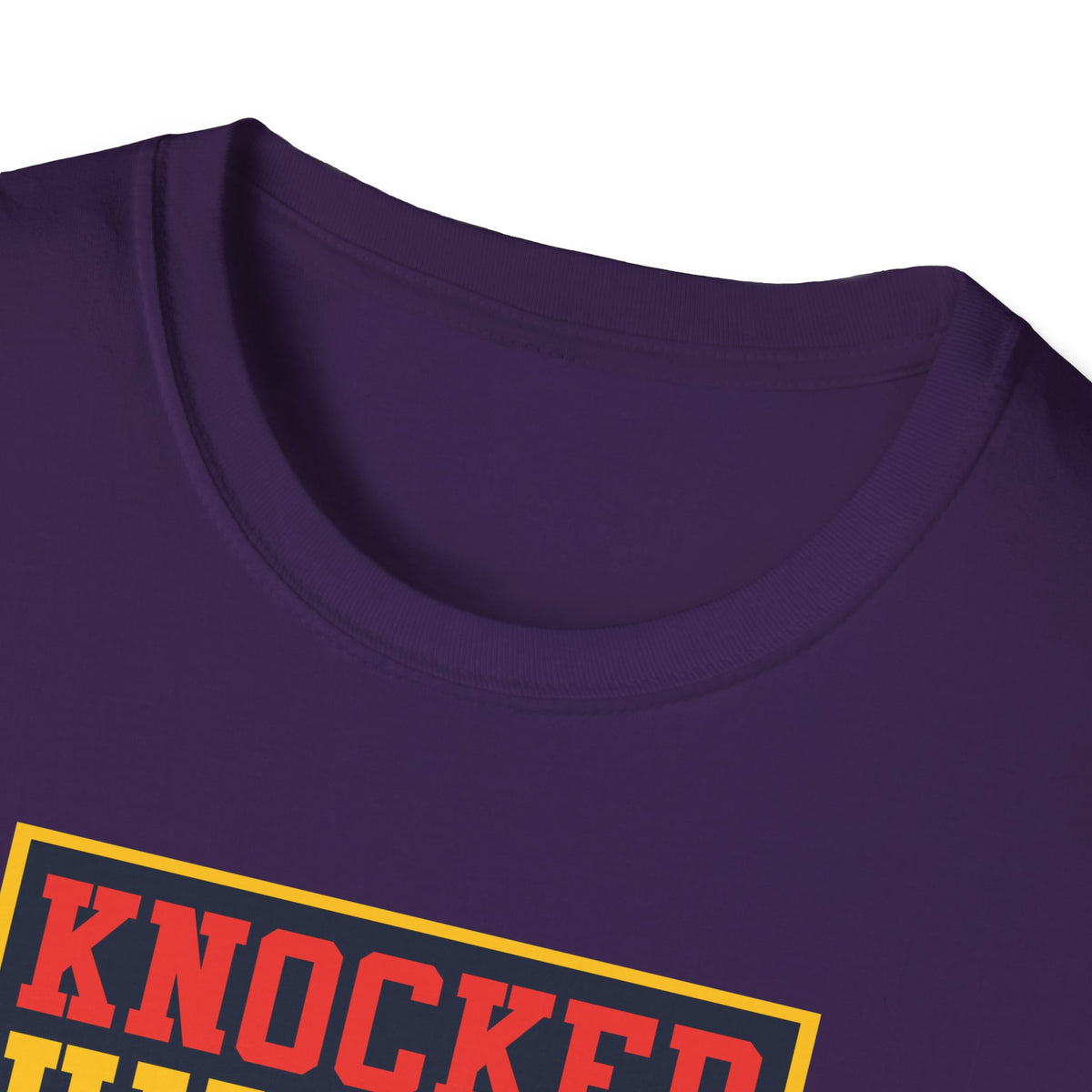 Close-up of "Knocked Him Out" robot boxing print on purple t-shirt collar, retro arcade graphic detail