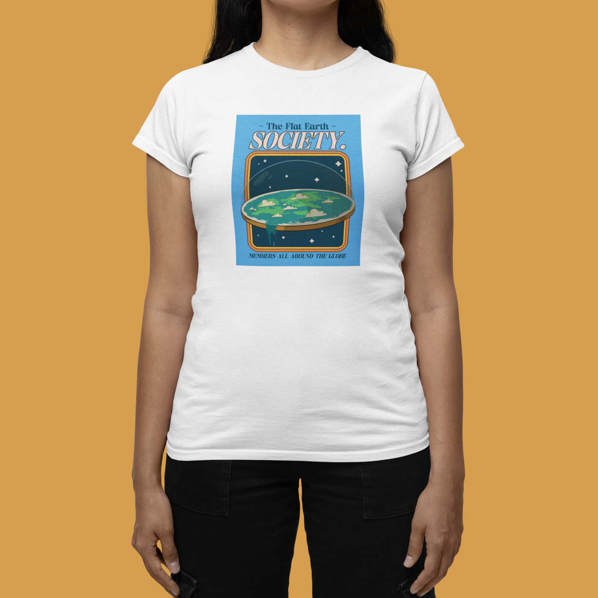 'The Flat Earth Society' women's tee in white, flat lay on mustard backdrop, funny satire gift