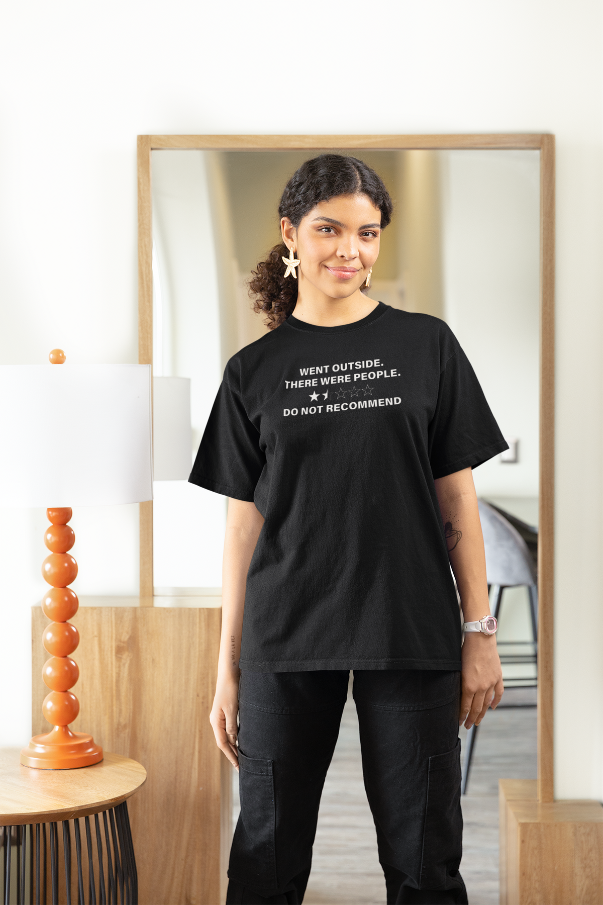 'Went Outside There Were People' Women's Tee in black, woman wearing it at home, sarcastic introvert tee