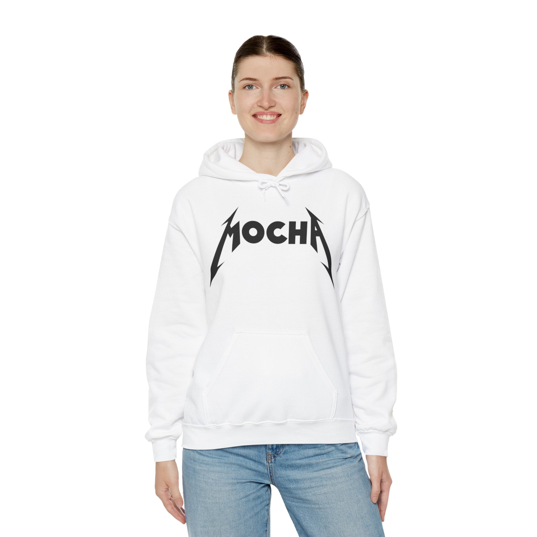 A person wearing a white Mocha - Hooded Sweatshirt with the word "MOCHA" in bold, stylized letters stands facing the camera, smiling, and posing with hands down. The hoodie, known for its style and comfort, features a front pouch pocket and drawstrings for a unique and tasteful look.