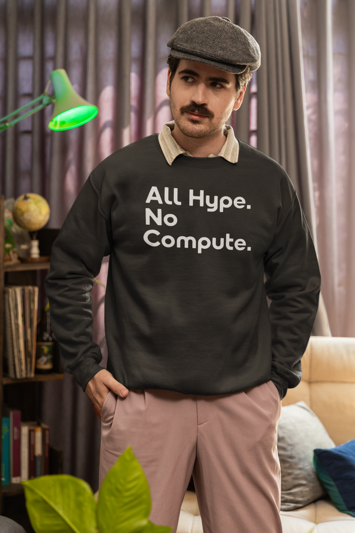 'All Hype. No Compute.' sweatshirt in black, bearded man wearing it in a cozy living room, funny tech gift