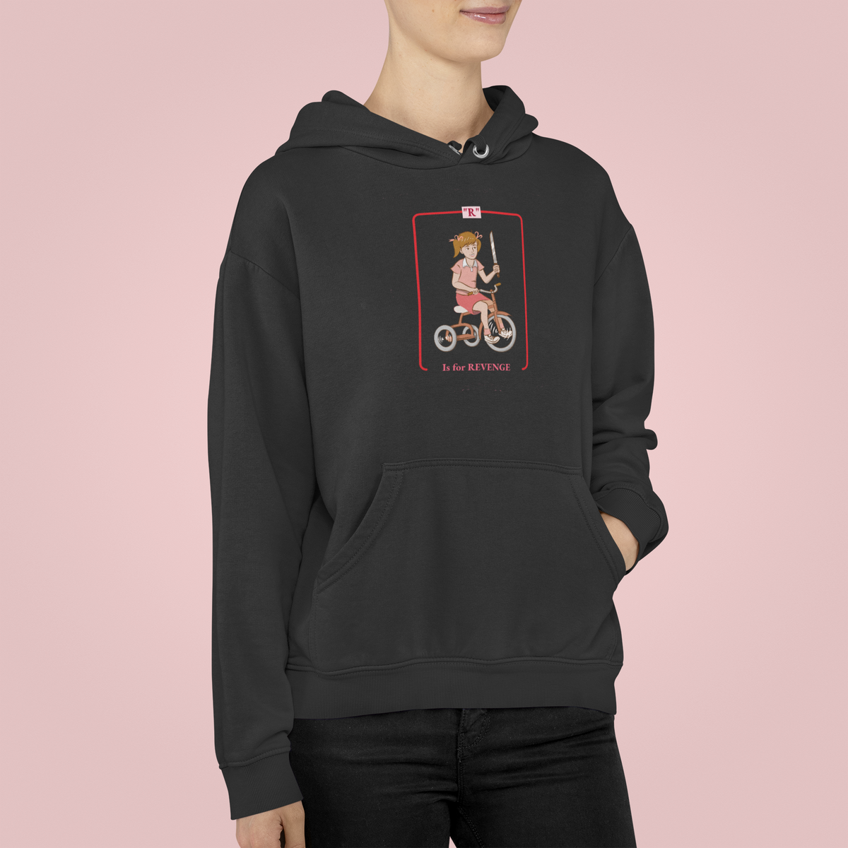 'R is for Revenge' tricycle girl graphic hoodie in black, woman wearing it on pink backdrop, funny gift