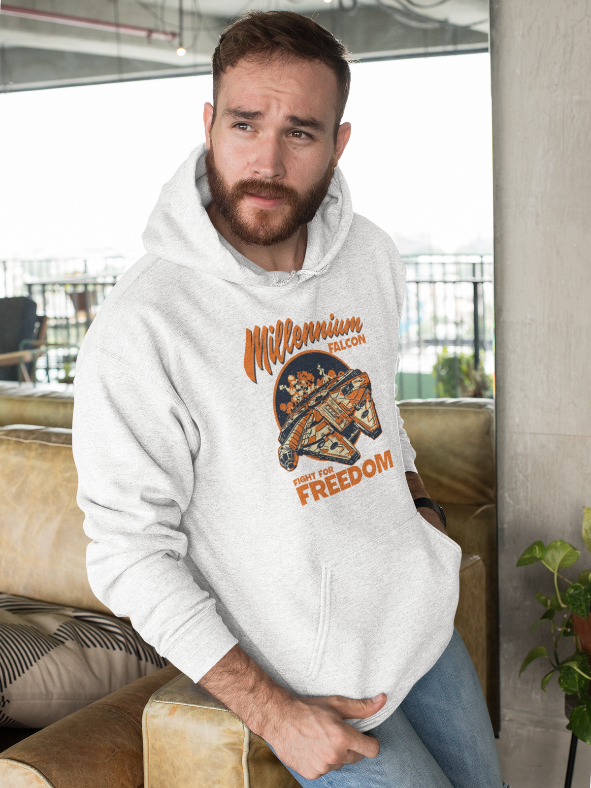'Millennium Falcon Fight for Freedom' hoodie in heather gray, bearded man wearing it indoors, cozy geek gift idea