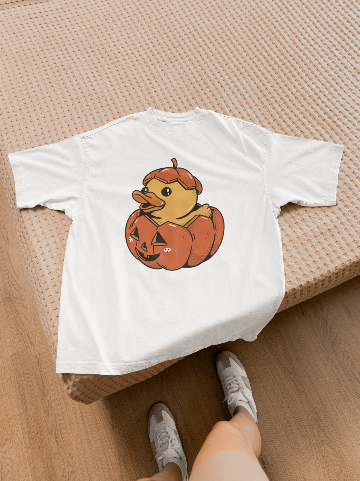 Halloween duck t-shirt in white, flat lay on a wooden bed frame, funny fall gift for duck lovers
