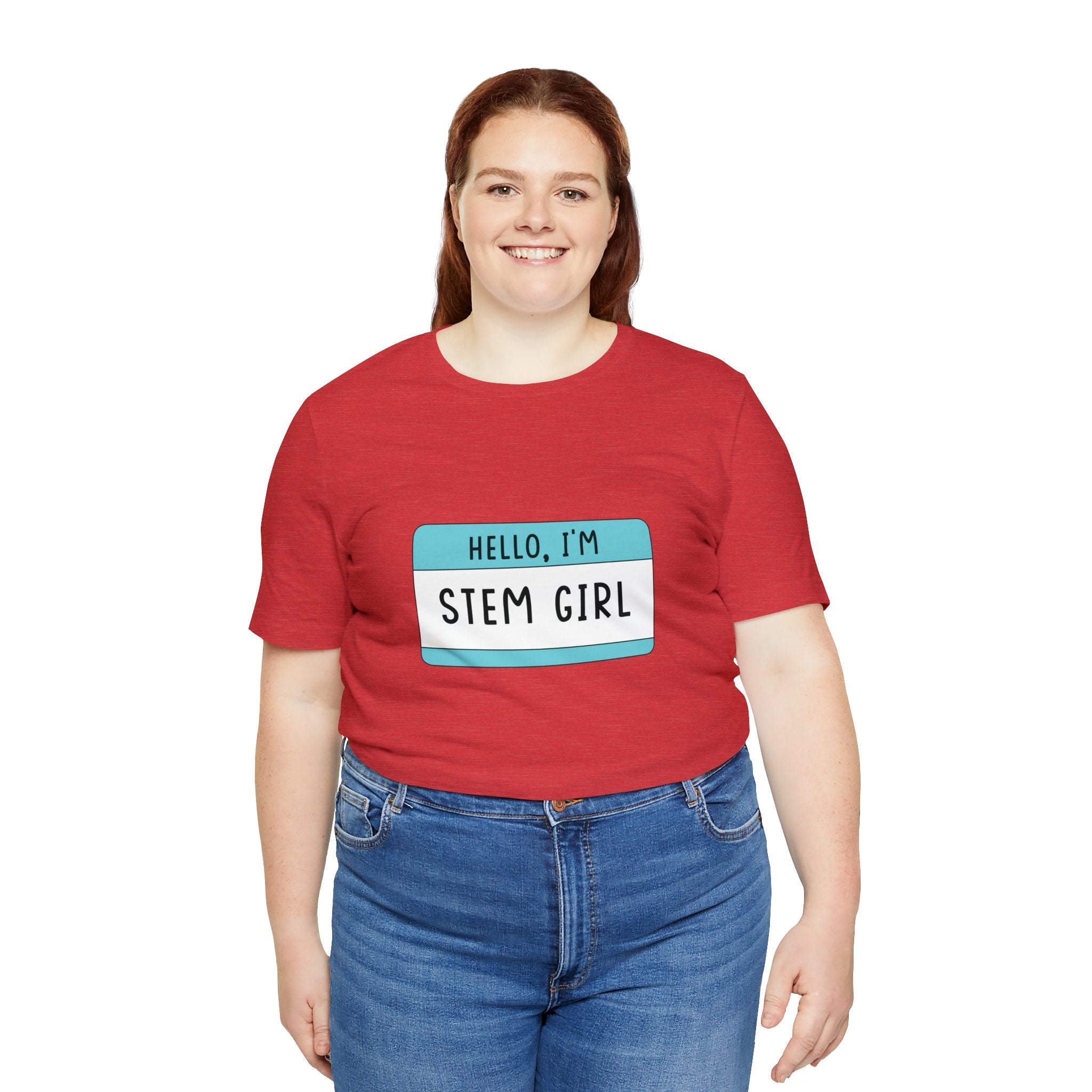 A woman in a red Hello, I'm Stem Girl T-Shirt and blue jeans, smiling at the camera.