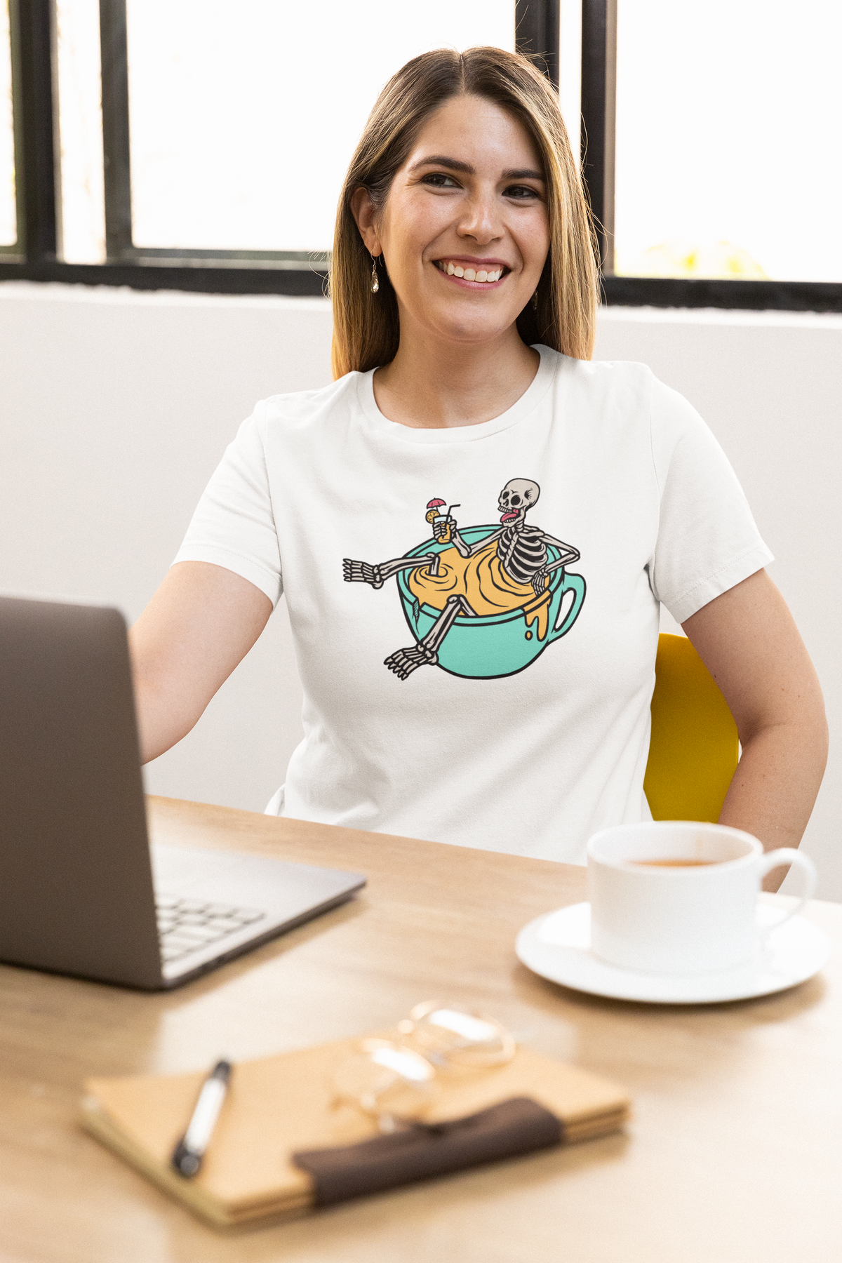 'Relaxing Skull' t-shirt in white, woman wearing it at desk with coffee, funny gift for coffee lovers