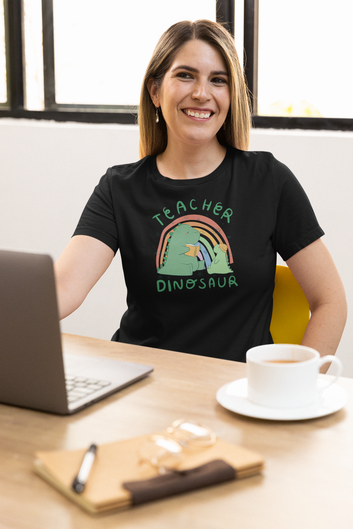 'Teacher Dinosaur' t-shirt in black, woman at an office desk