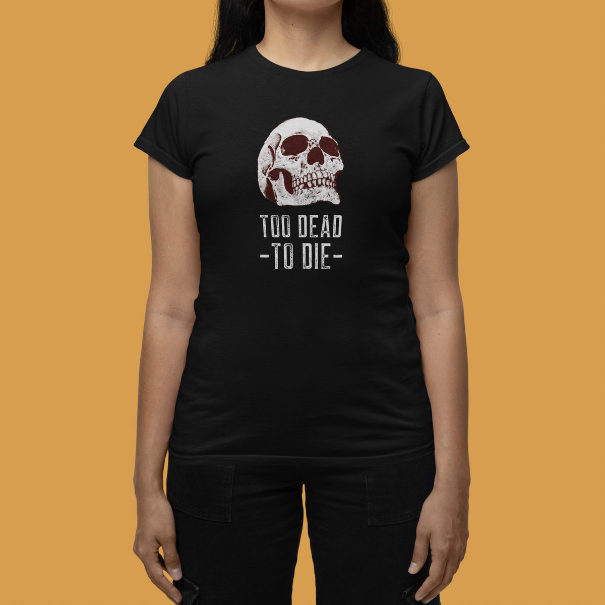 'Too Dead To Die' skull graphic women's t-shirt in black, close-up on model, orange backdrop, gothic gift