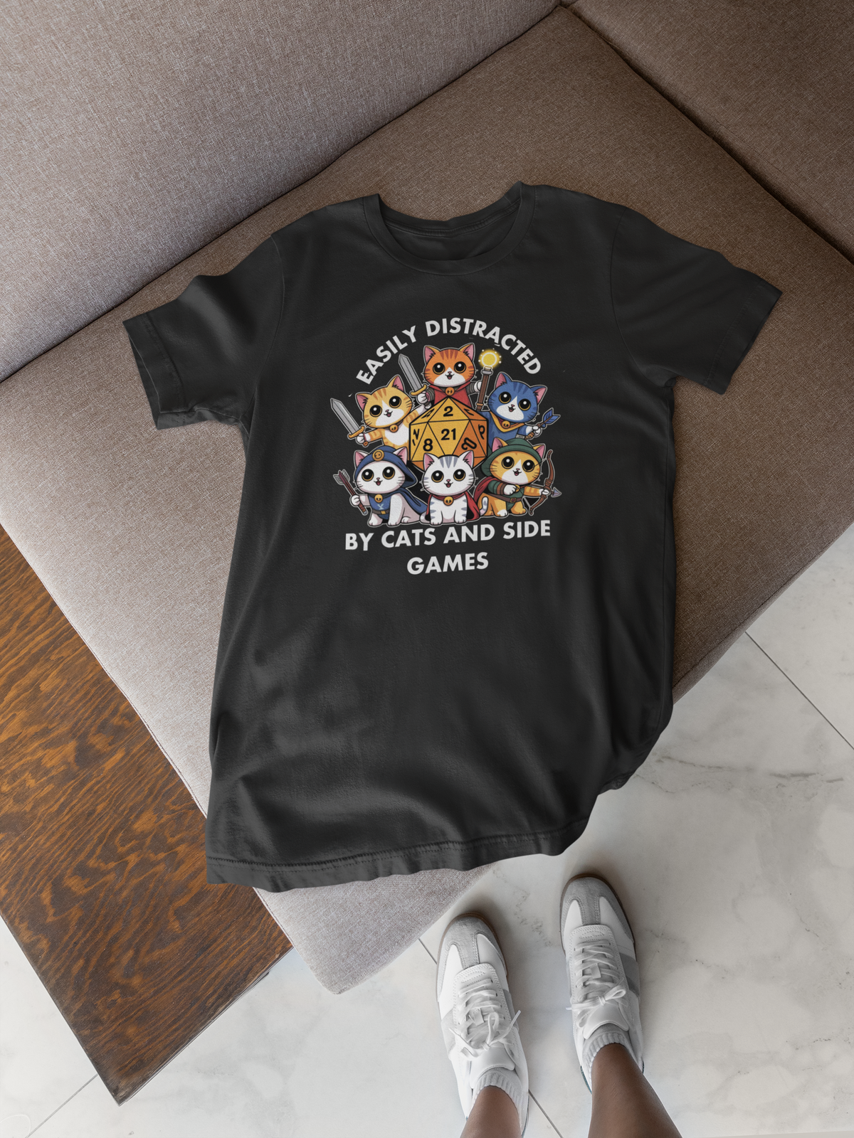 'Easily Distracted By Cats And Side Games' tee flat lay on rug with sneakers, colorful cat gamer gift