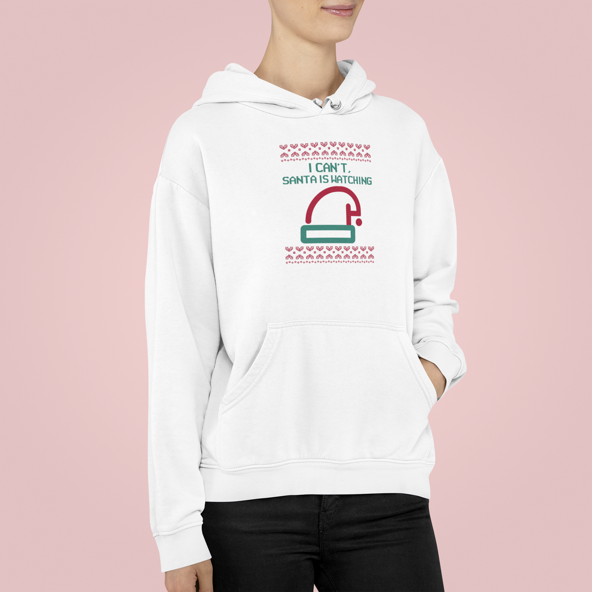 'I Can't Santa Is Watching' camera graphic hoodie in white, woman wearing it on pink backdrop, funny Christmas gift