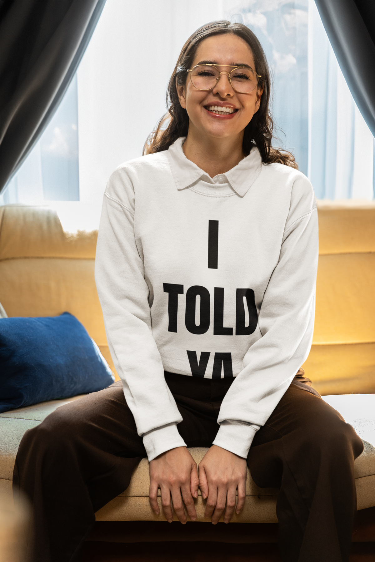 "I Told Ya" sweatshirt in white, woman modeling it on a sofa, funny sarcastic gift for know-it-alls