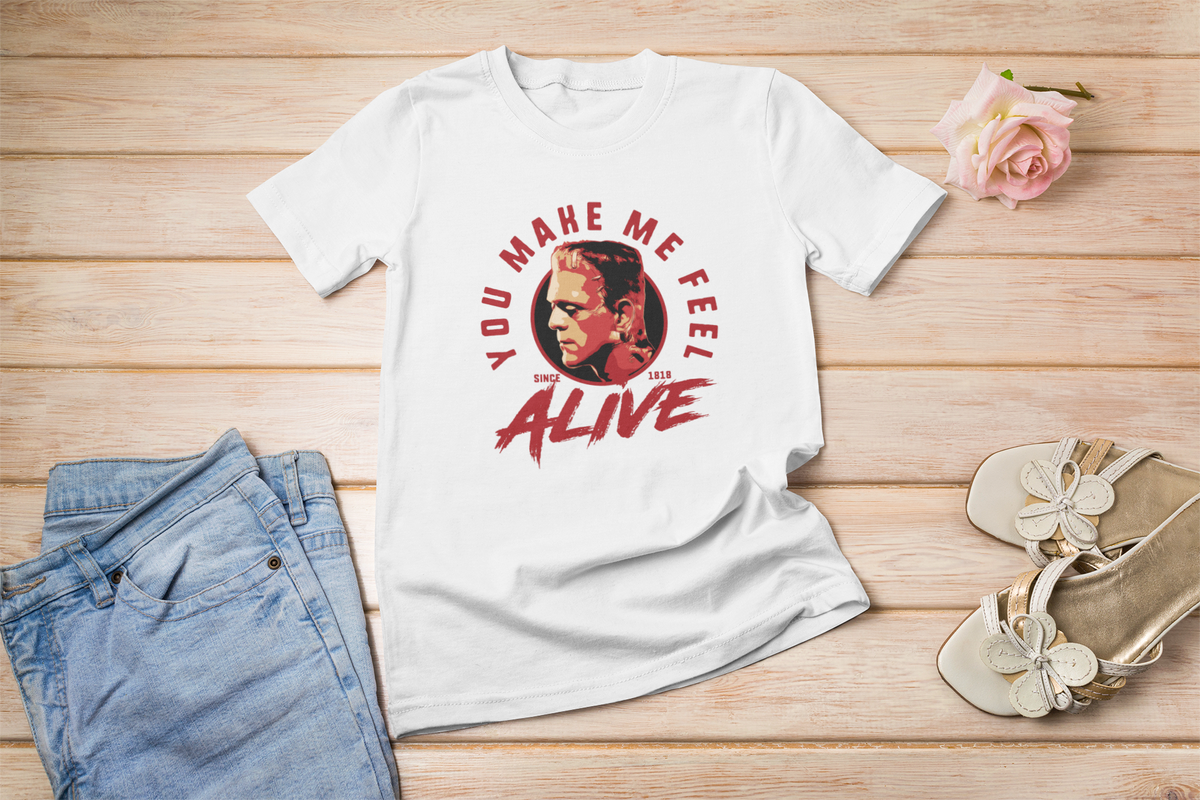 "You Make Me Feel Alive" portrait graphic t-shirt in white, flat lay with shoes and flowers, retro gift idea