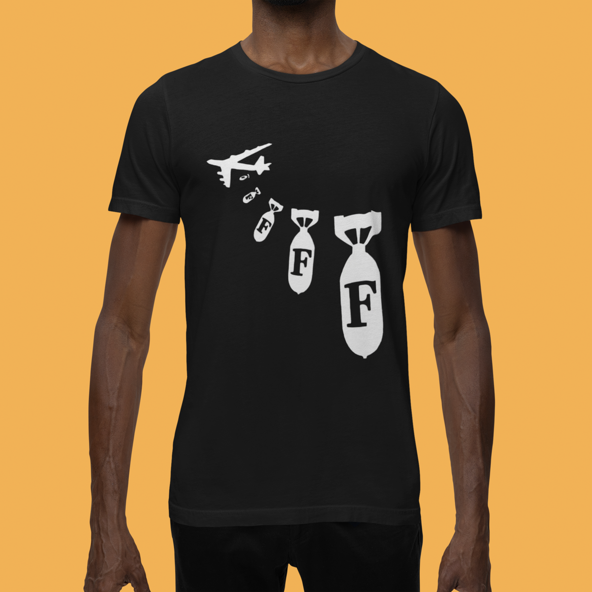 "F Bomb" t-shirt in black, man wearing it on mustard background, funny sarcastic gift tee