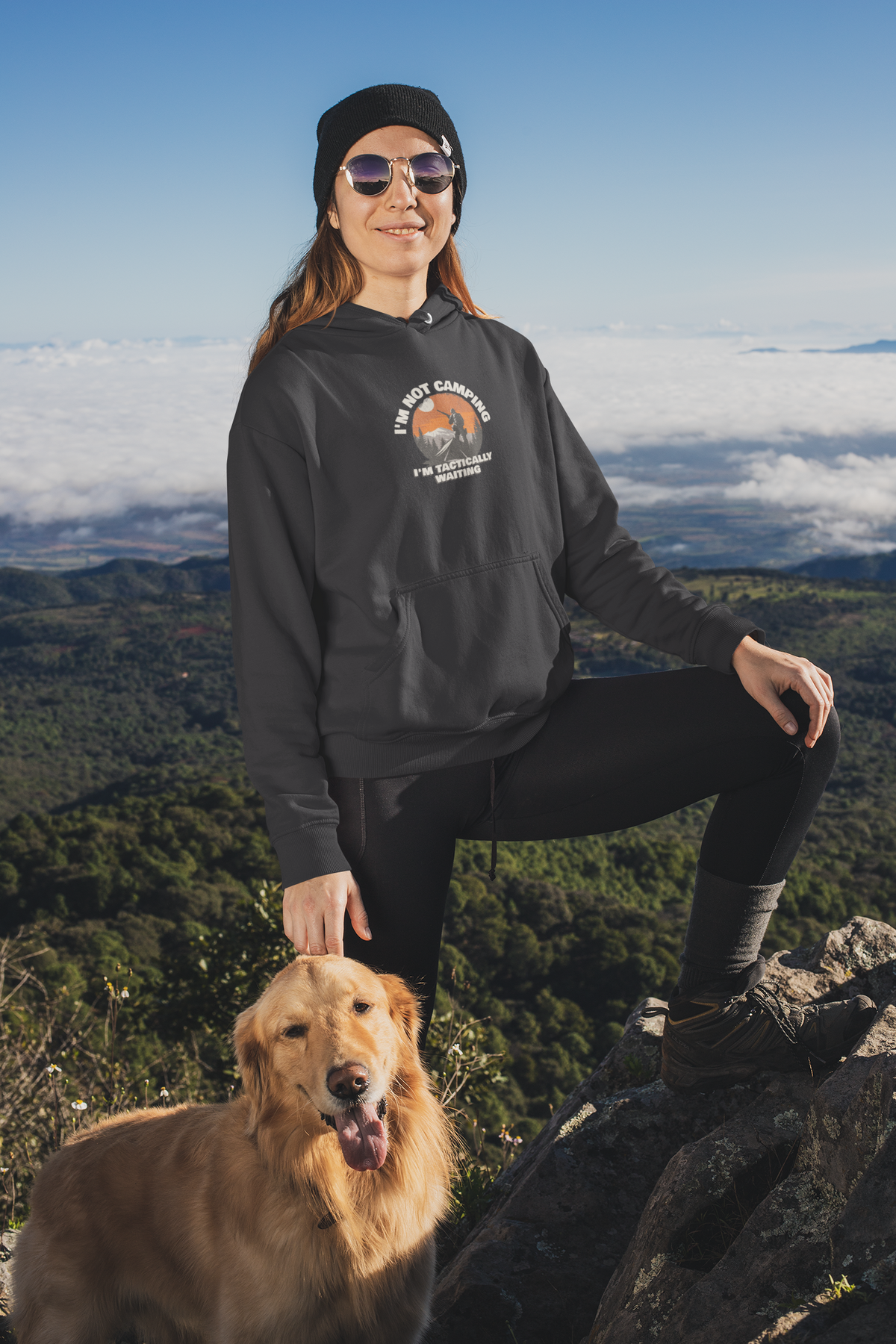 'I'm Not Camping' hiker graphic hoodie in black, woman wearing it on a mountain with her dog