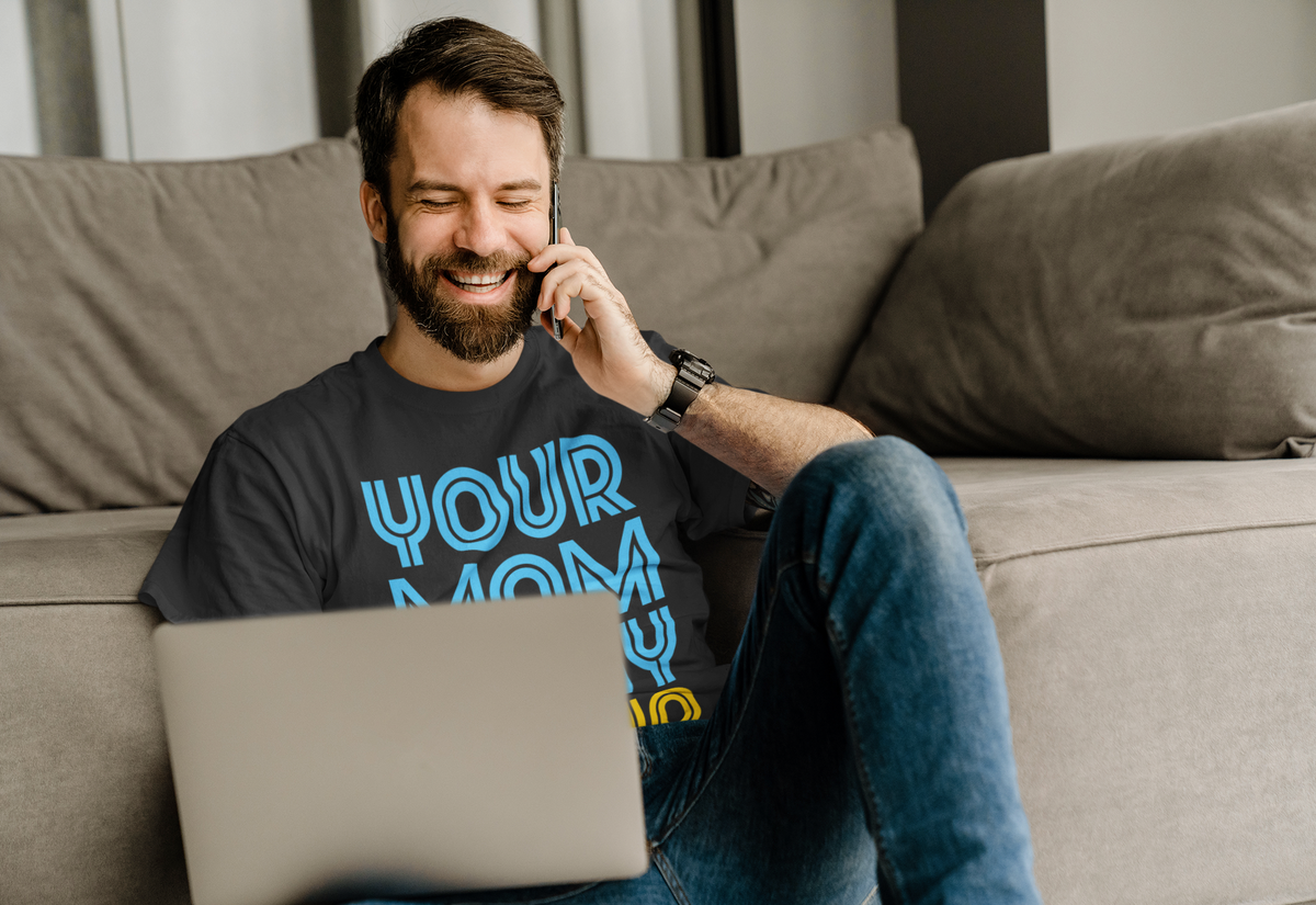 'Your Mom Is My Cardio' tee in black, man wearing it on the phone with a laptop, funny sarcastic gift shirt