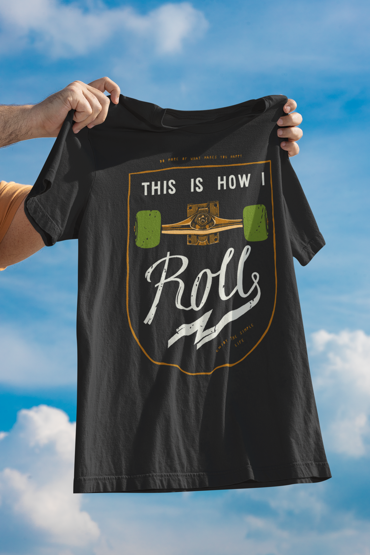 "This Is How I Roll" skateboard t-shirt in black, held up outdoors against sky, funny skater gift