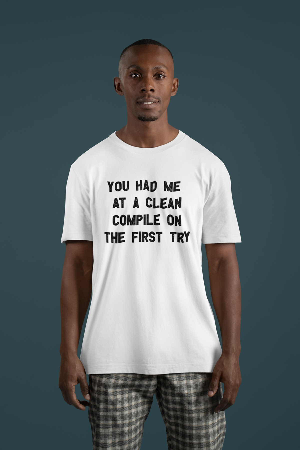 'You Had Me at a Clean Compile on the First Try' t-shirt in white, man wearing it on a dark backdrop, funny coder gift