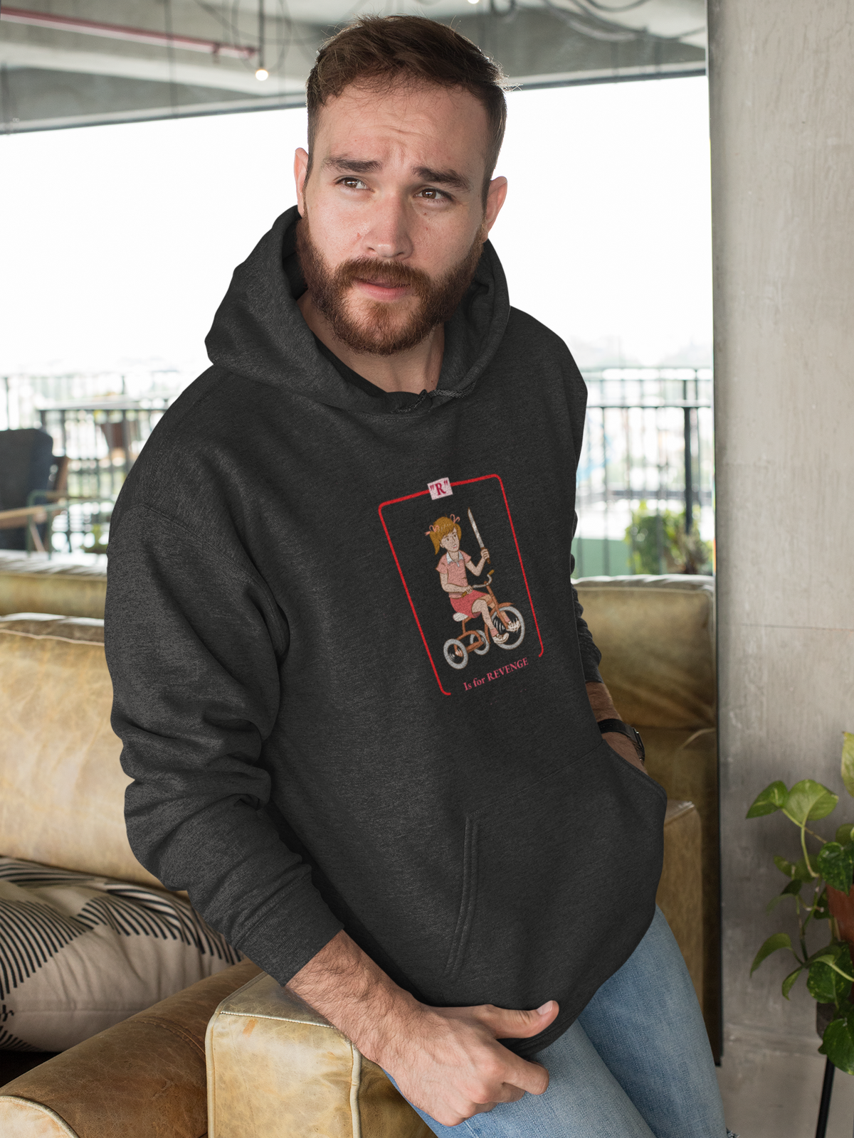 'R is for Revenge' tricycle girl graphic hoodie in charcoal, bearded man wearing it indoors, funny gift