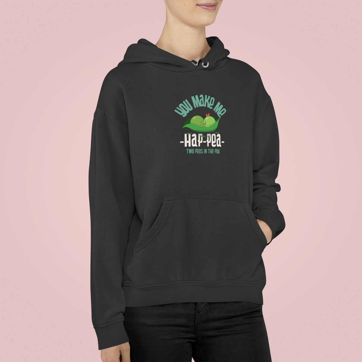 'You Make Me Ha-Pea' pea pun hoodie in charcoal, woman wearing it, pink backdrop, veggie pun gift