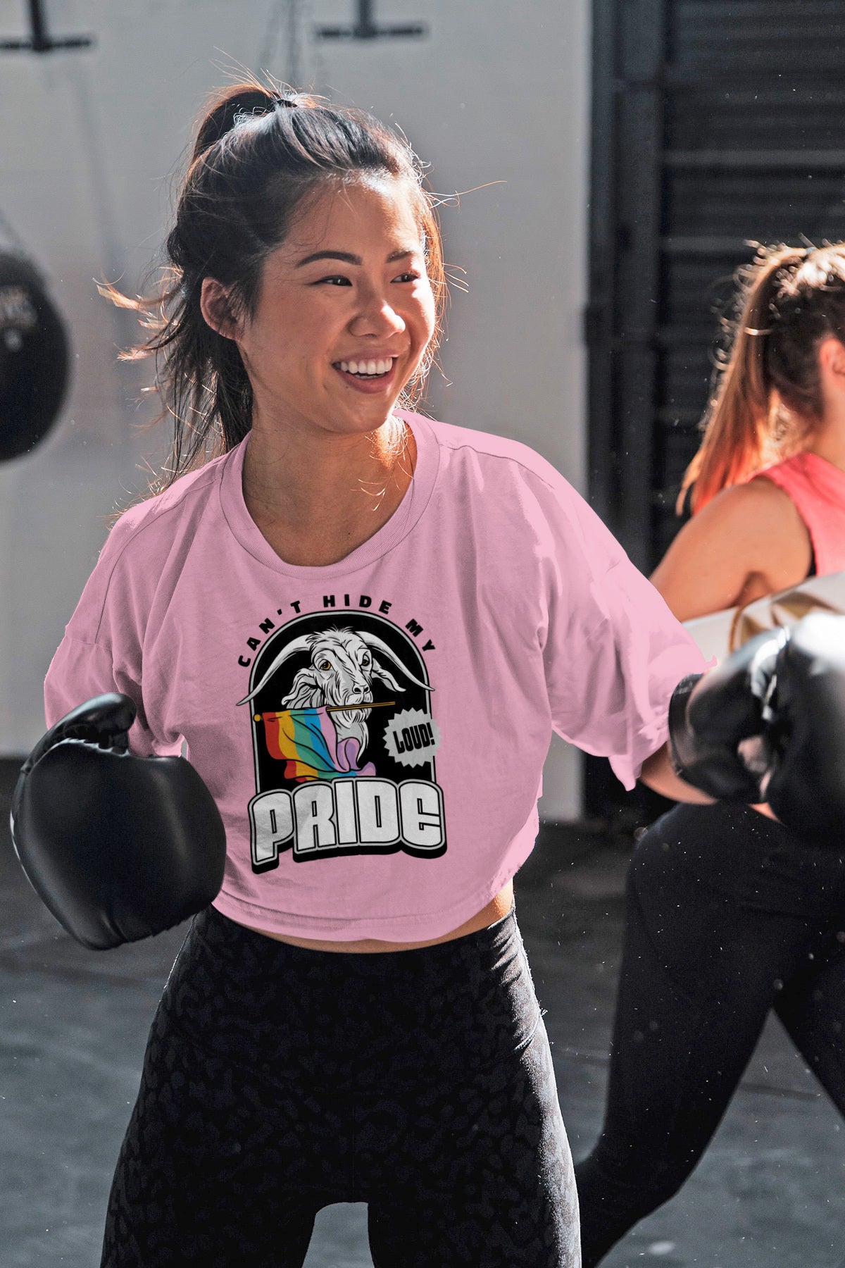 A woman wearing a pink crop top and boxing gloves from Printify's "Can't Hide My Pride" collection.