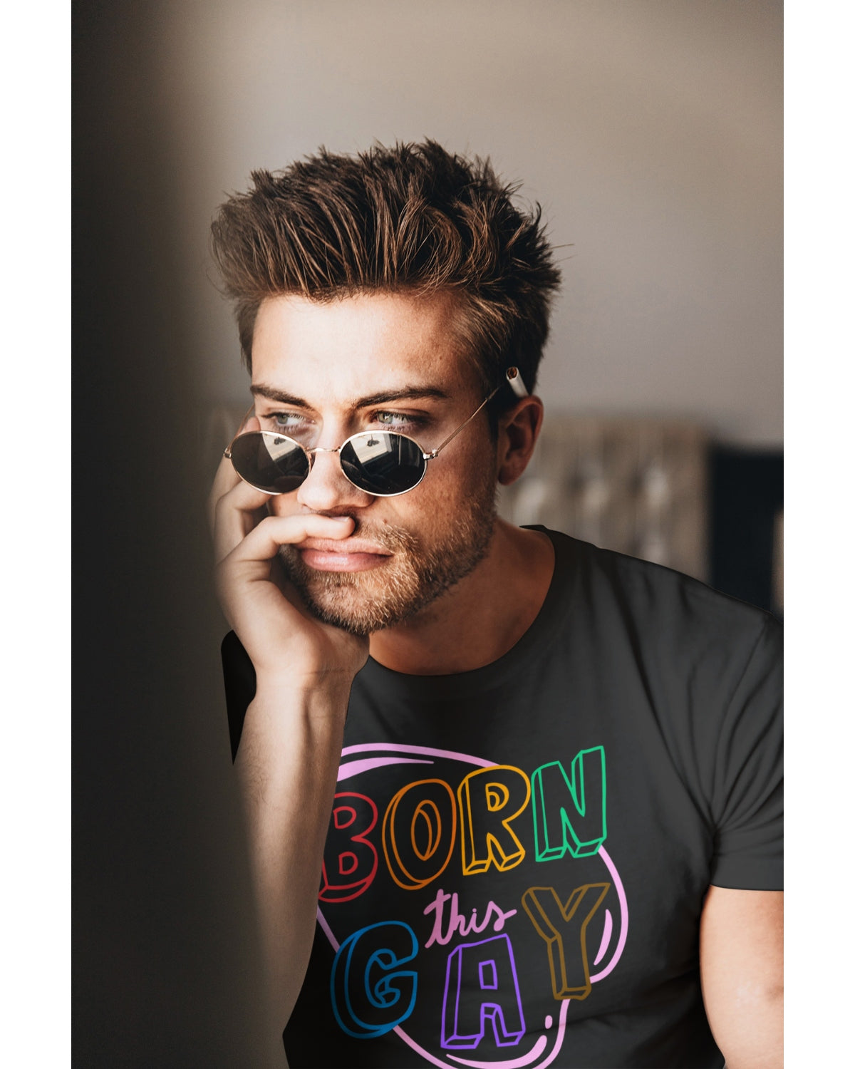 A man wearing pride sunglasses and a Born This Gay T-shirt.