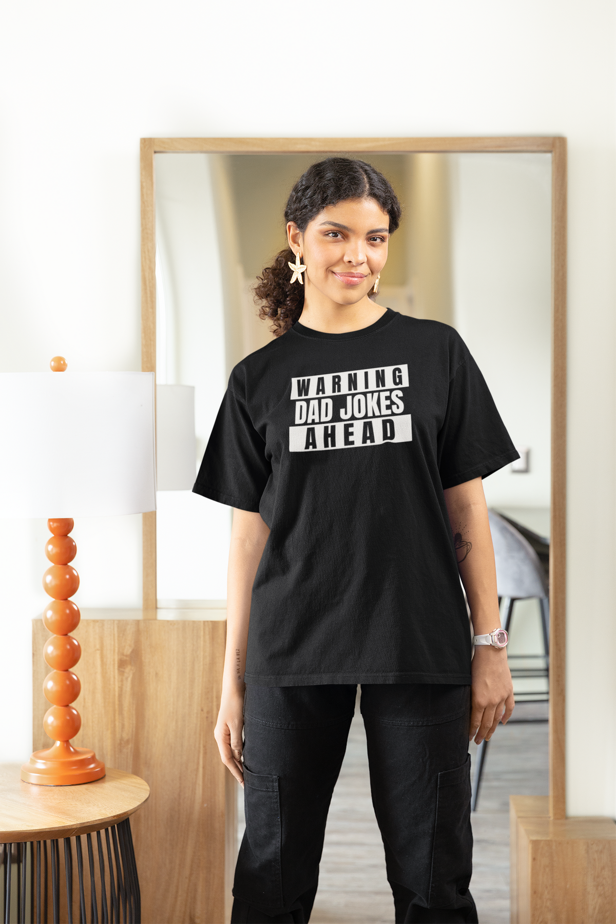 'Warning Dad Jokes Ahead' women's tee in black, woman wearing it at home, funny Father's Day gift for her