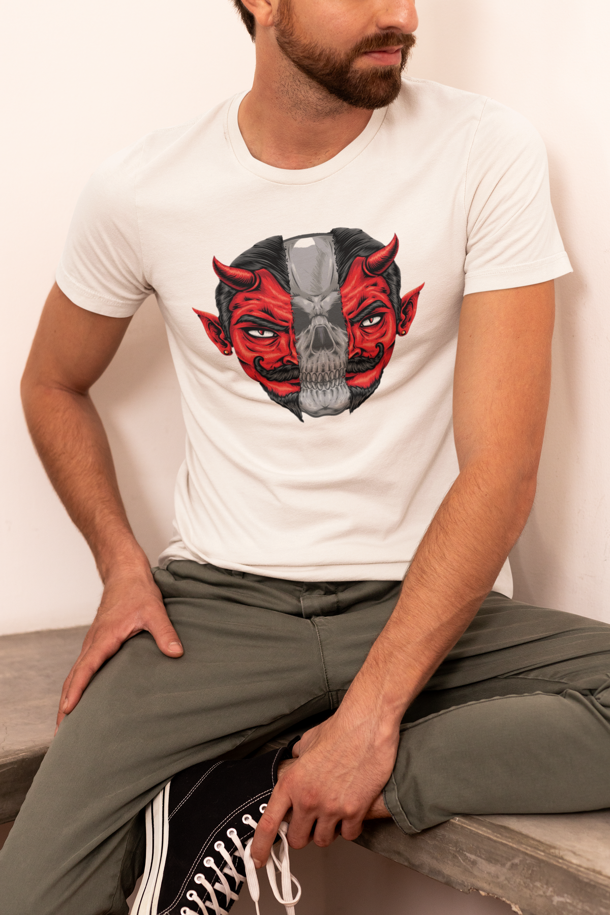 Vixxan Warrior demon skull t-shirt in cream, man sitting outdoors wearing it