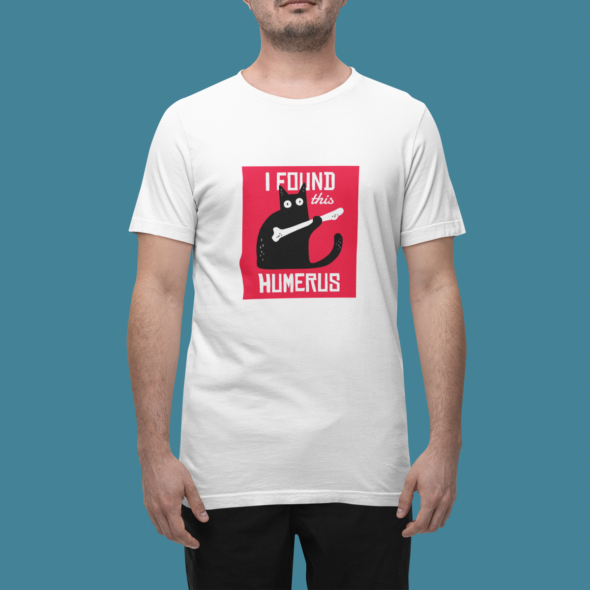 'I Found This Humerus' t-shirt in white, man in a studio