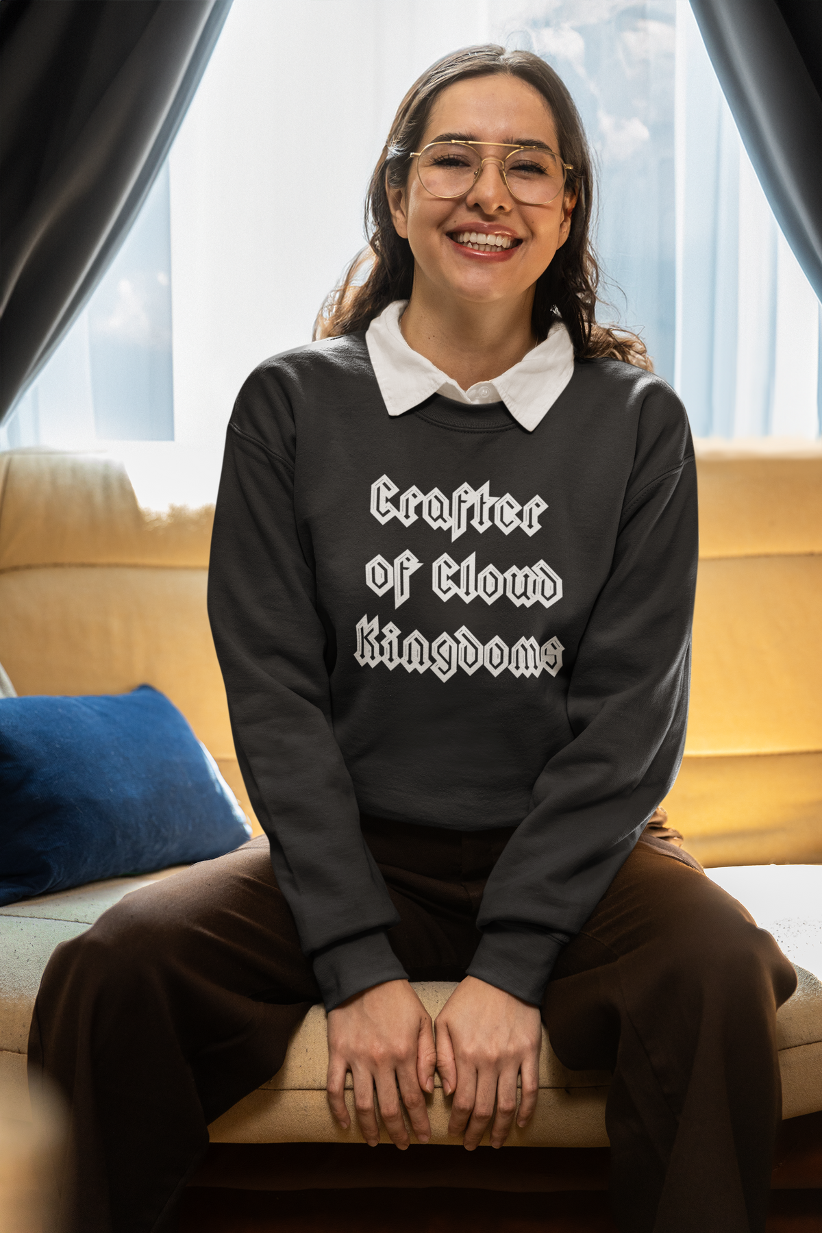 'Crafter of Cloud Kingdoms' sweatshirt in black, woman sitting on a couch, funny coder sweatshirt gift for developers