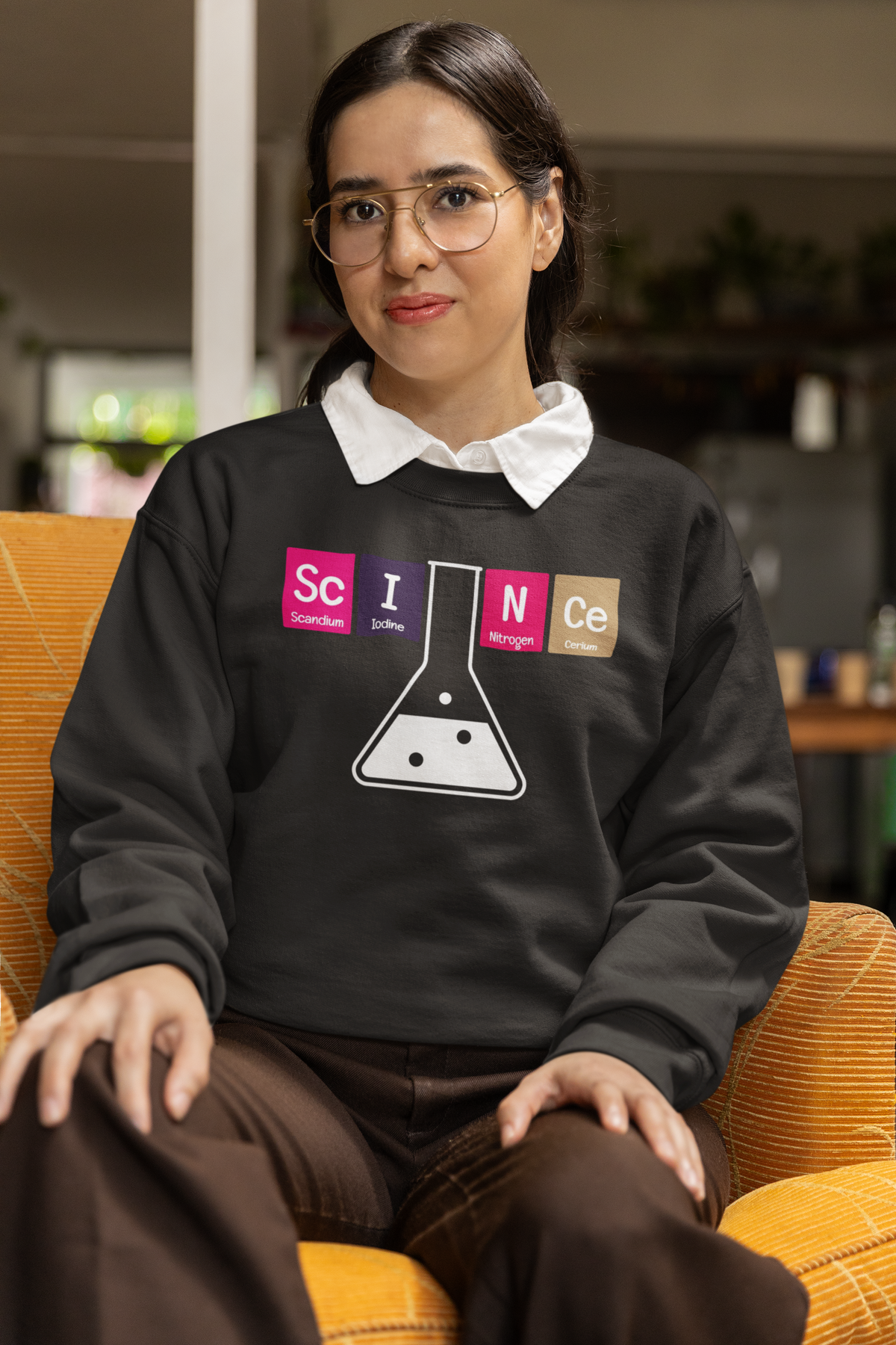 'Science' periodic table sweatshirt in black, woman wearing it seated indoors, funny science pun gift