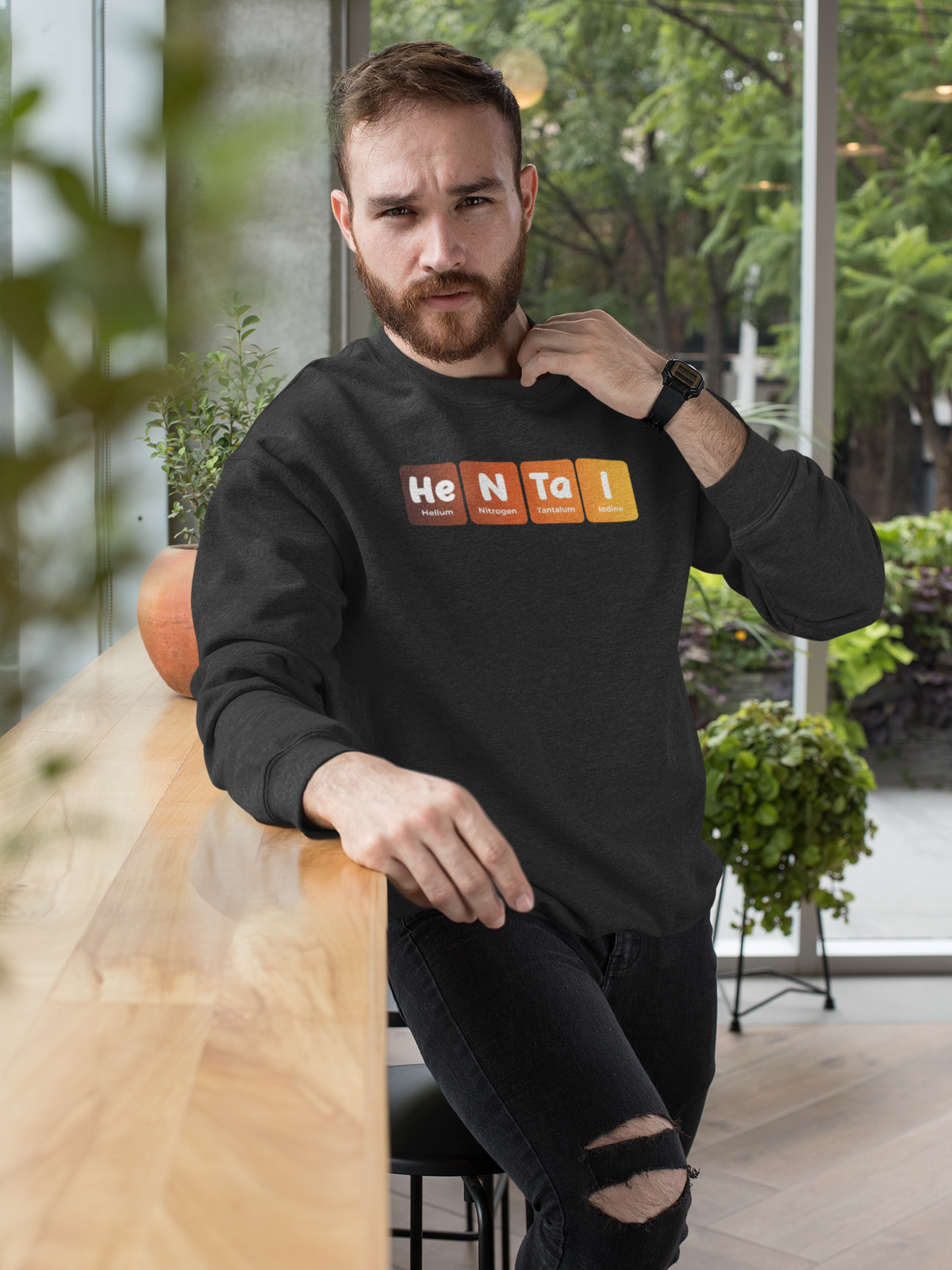 'Hentai' periodic table sweatshirt in black, bearded man wearing it at an outdoor cafe, funny anime pun gift