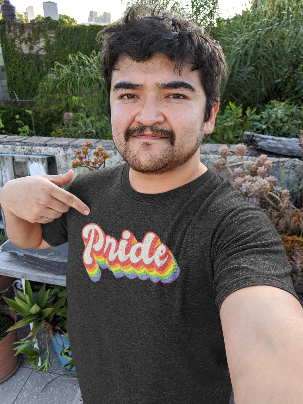 Pride Rainbow T-shirt in dark heather, man wearing it outdoors in a garden, LGBTQ pride shirt