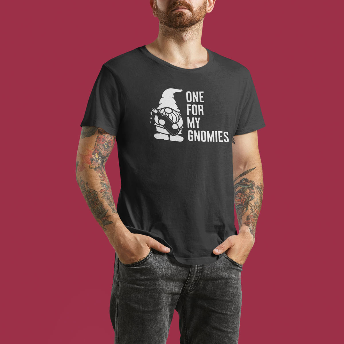One For My Gnomies t-shirt in black, man wearing it against a red backdrop, funny gnome pun gift