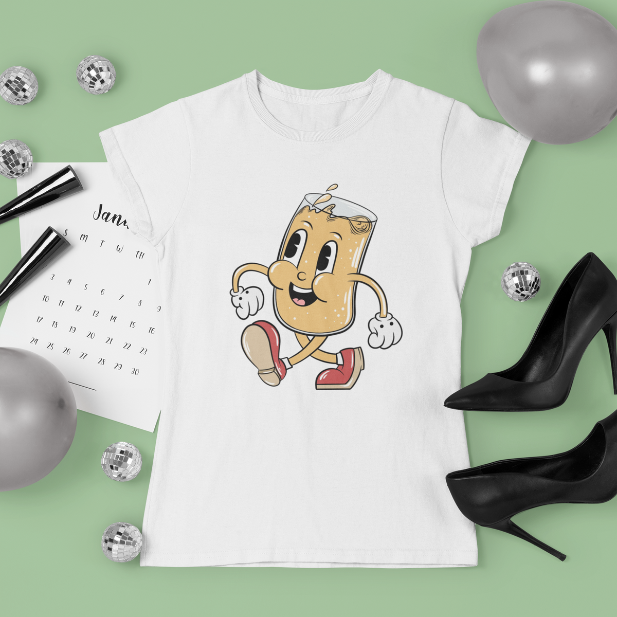 Cartoon beer mug t-shirt in white, flat lay styled with heels on green background, funny drinking gift