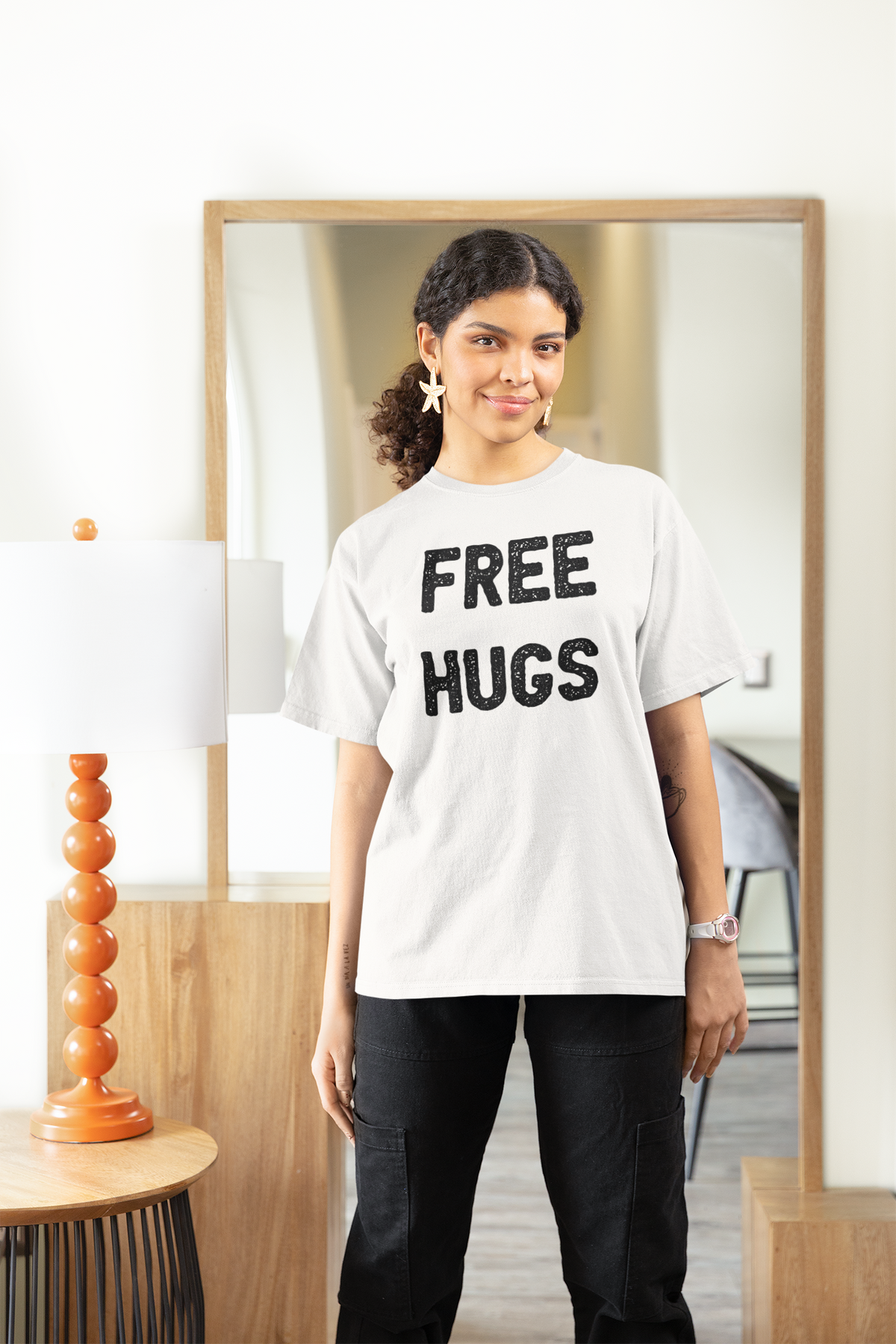 'Free Hugs' women's tee in white, woman wearing it at home, funny sarcastic shirt gift idea