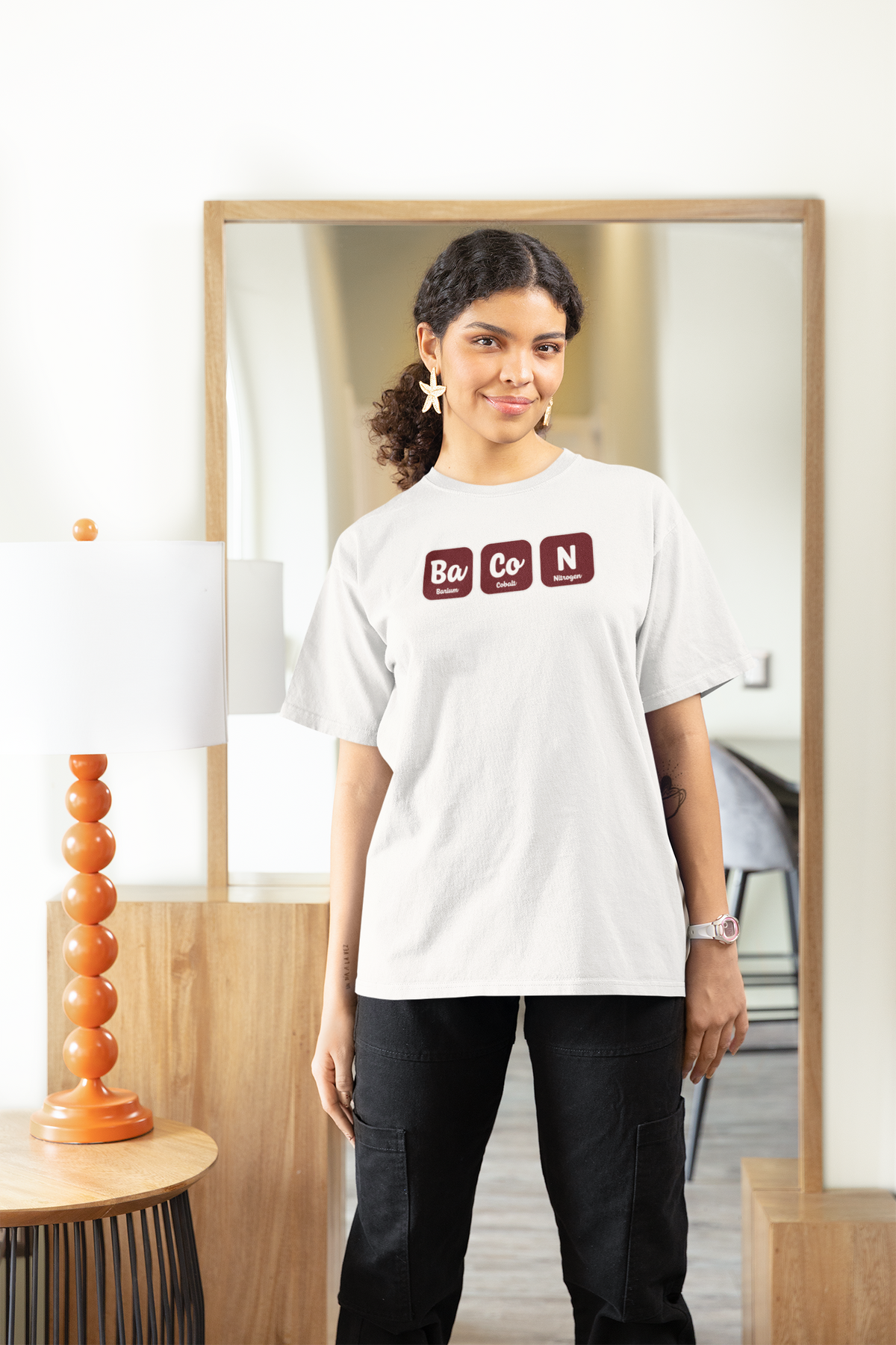 'Ba-Co-N' women's fitted t-shirt in white, woman wearing it oversized at home, cozy bacon lover gift